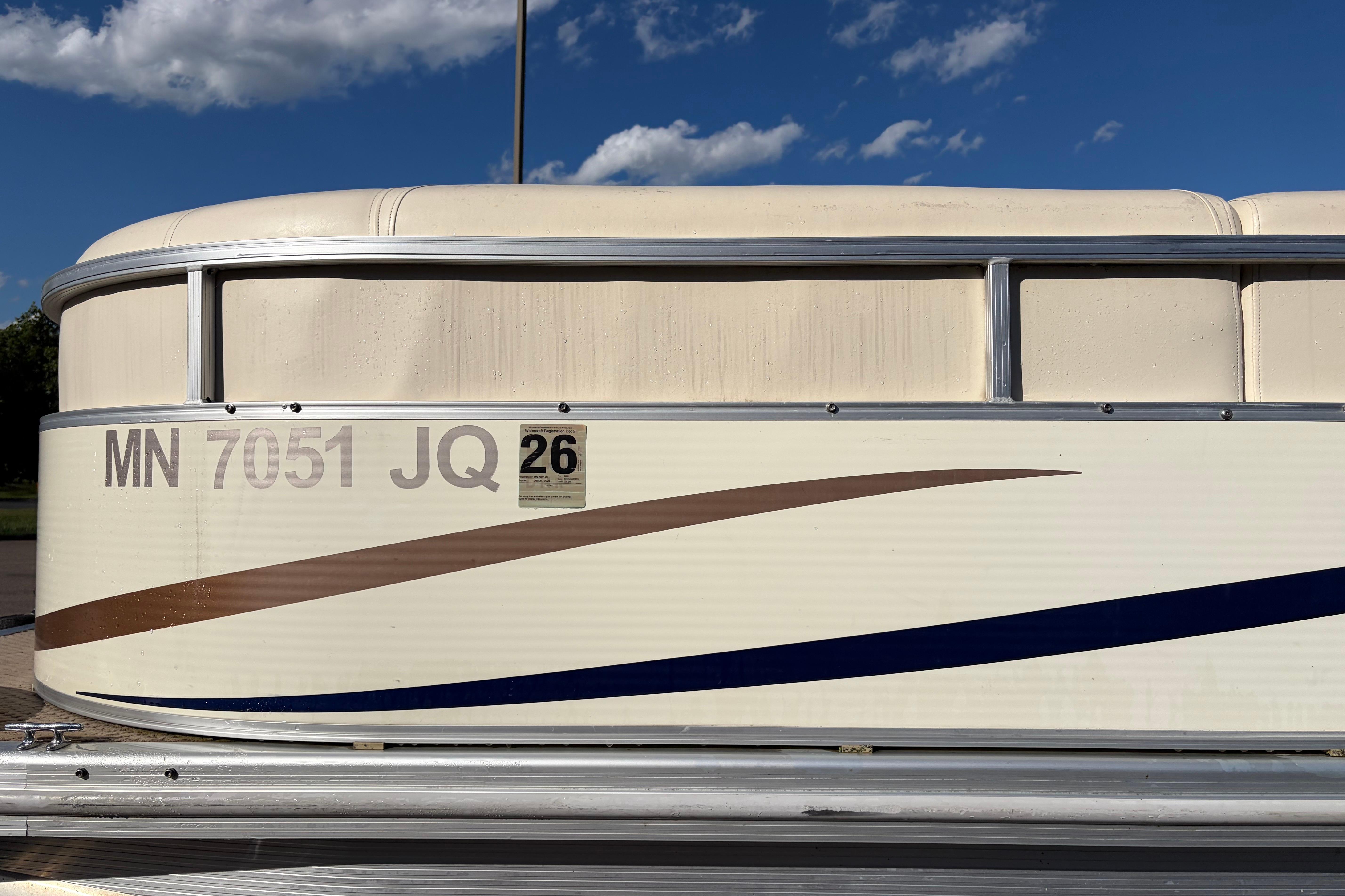 2003 Bennington 2250RSi pontoon boat with registration MN 7051 JQ under a blue sky.