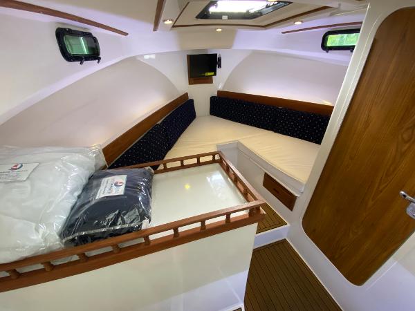 Interior of the 2015 Eastern 27 Islander with cozy seating and wood accents.