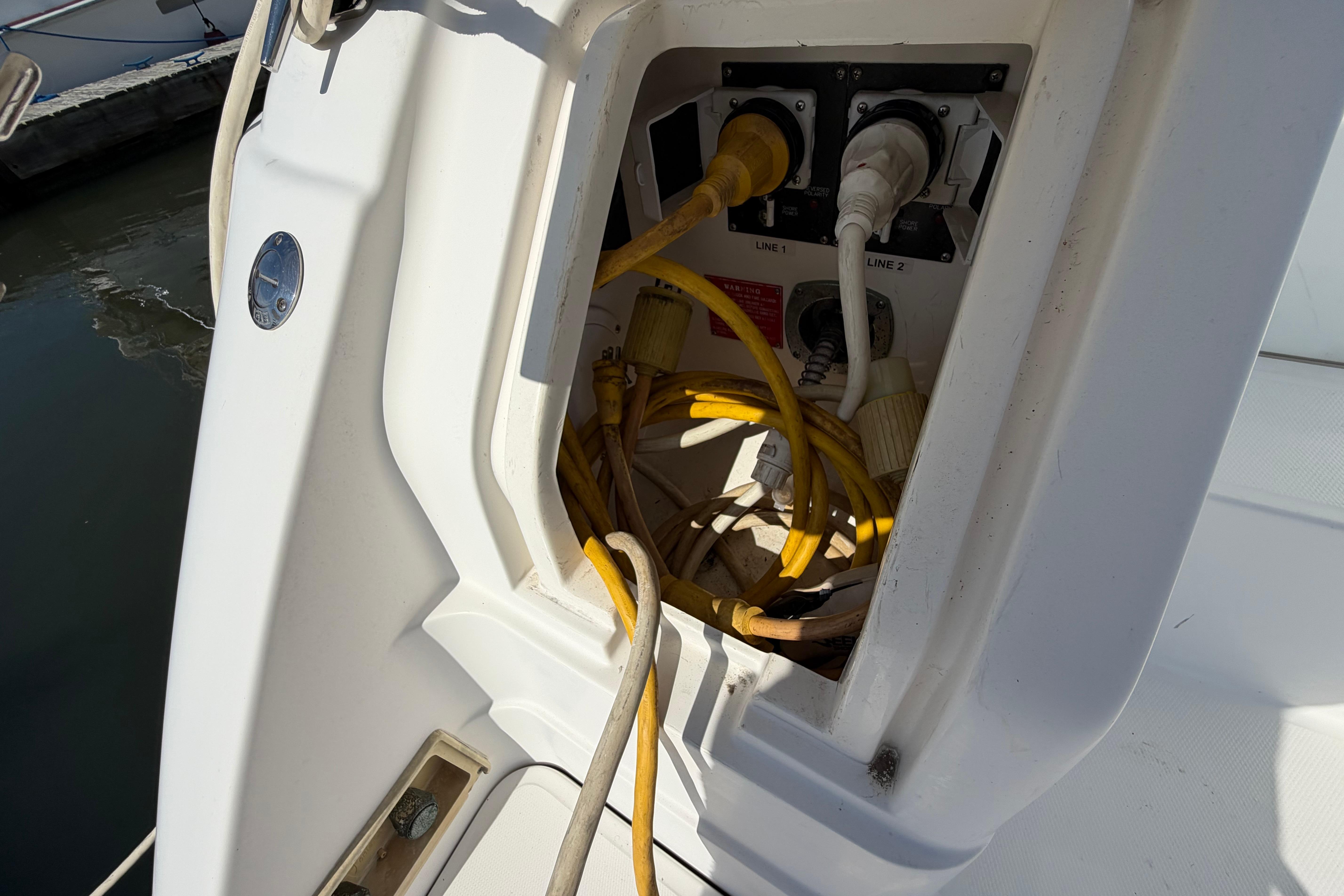 Electrical connections on a 2003 Regal Commodore 3260 boat, featuring power cables and outlets.