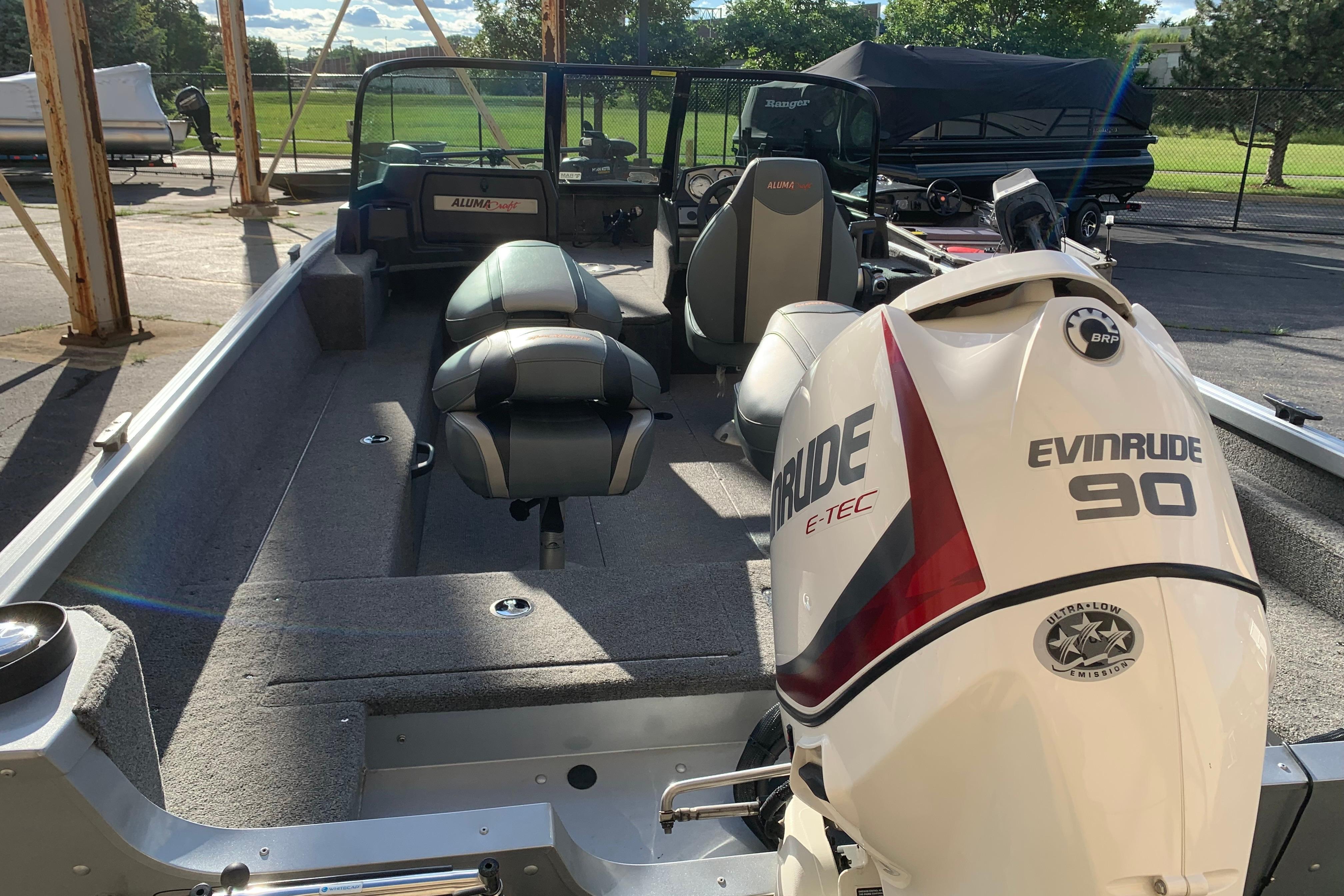 1993 Alumacraft Trophy 175 boat with Evinrude 90 engine, parked outdoors.