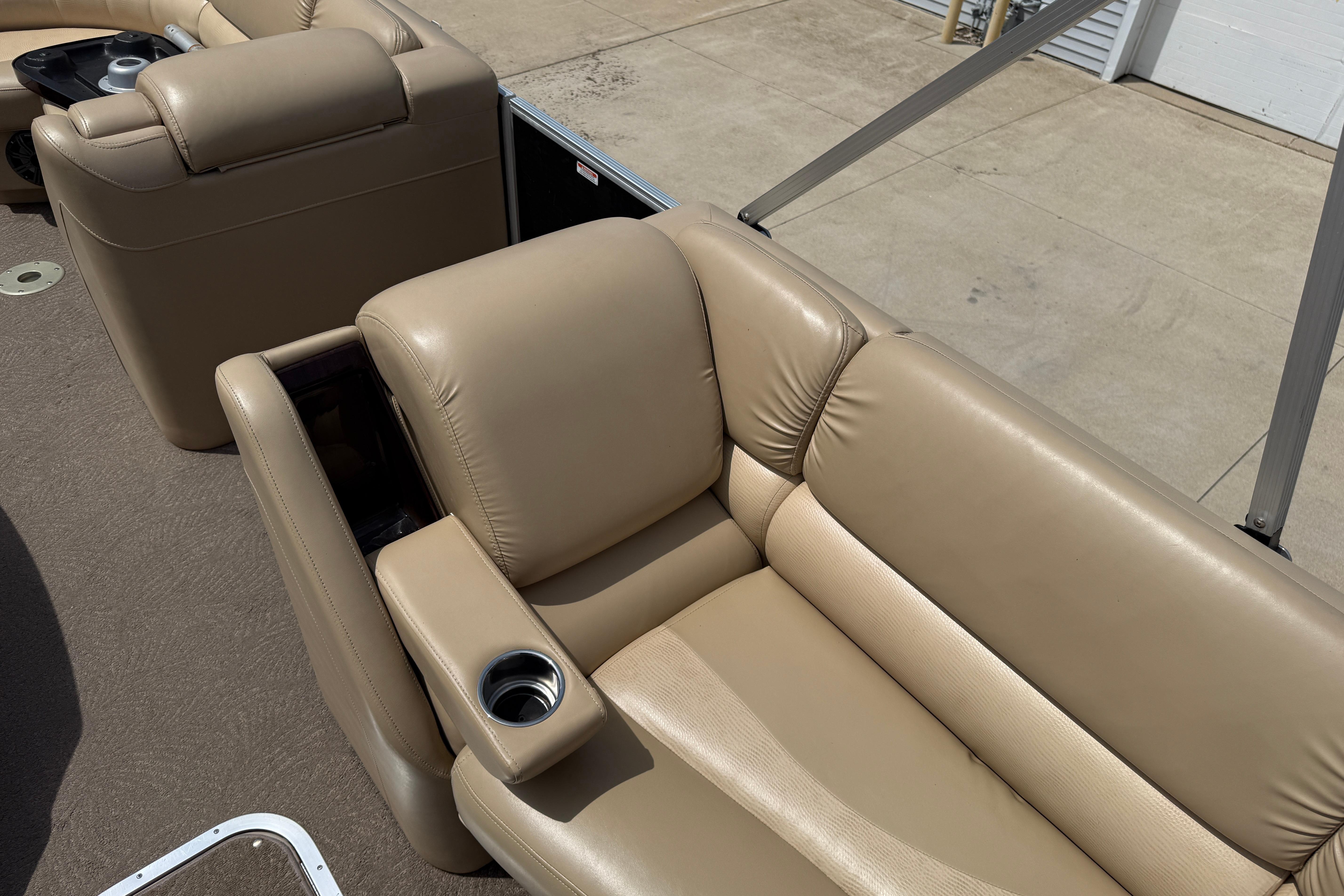 Luxurious beige seating on 2011 Bennington 2575QCW I/O boat, featuring cup holders and plush upholstery.