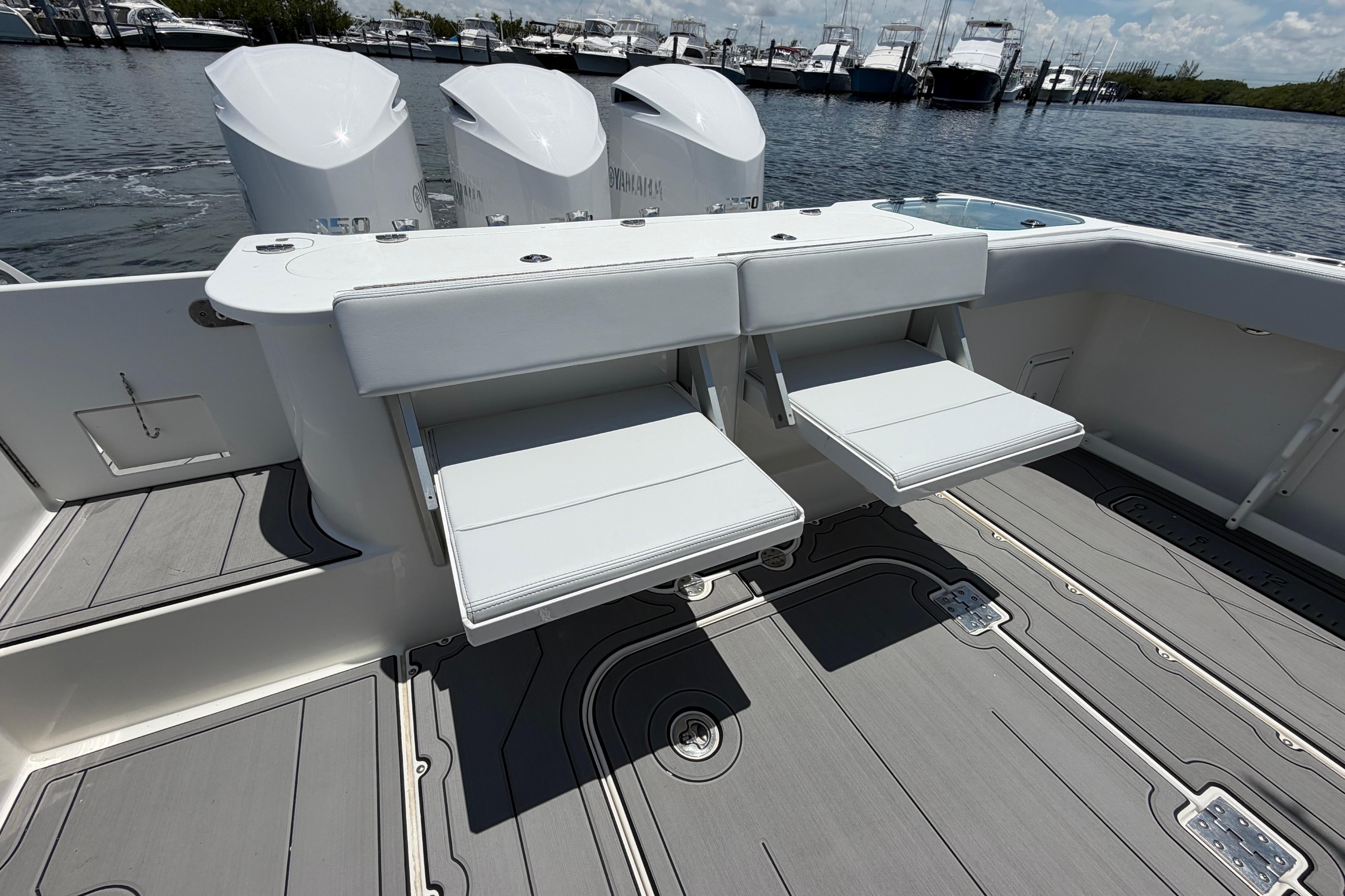 2009 Everglades 350LX boat with foldable seats and triple outboard engines, docked at marina.