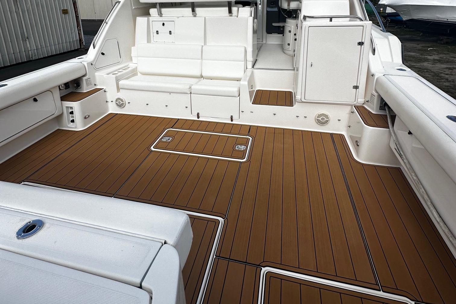 1999 Tiara Yachts 43 Open boat deck with white seating and wood flooring.