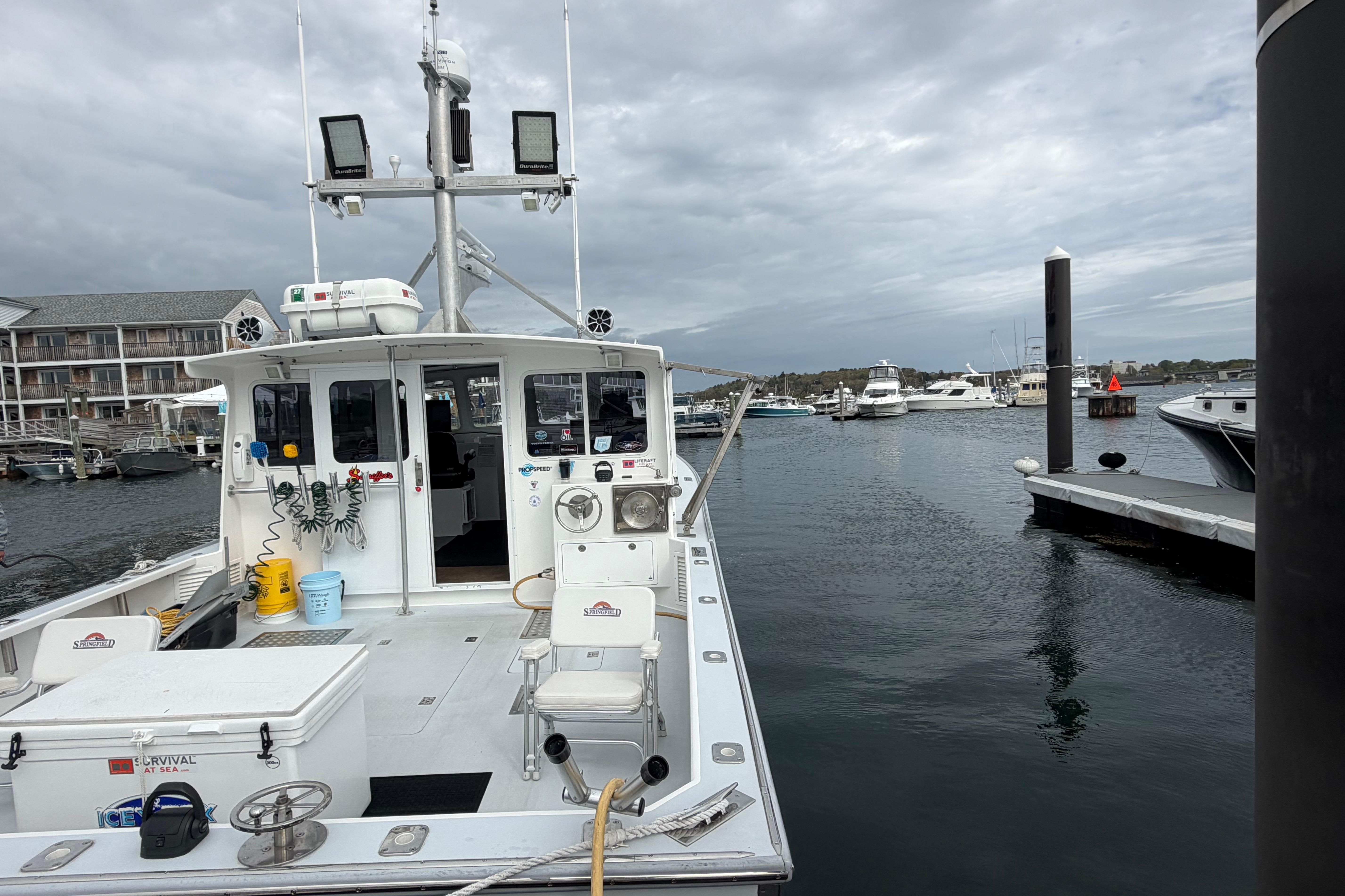 2018 H&H Marine Osmond Beal boat docked in a marina under cloudy skies.