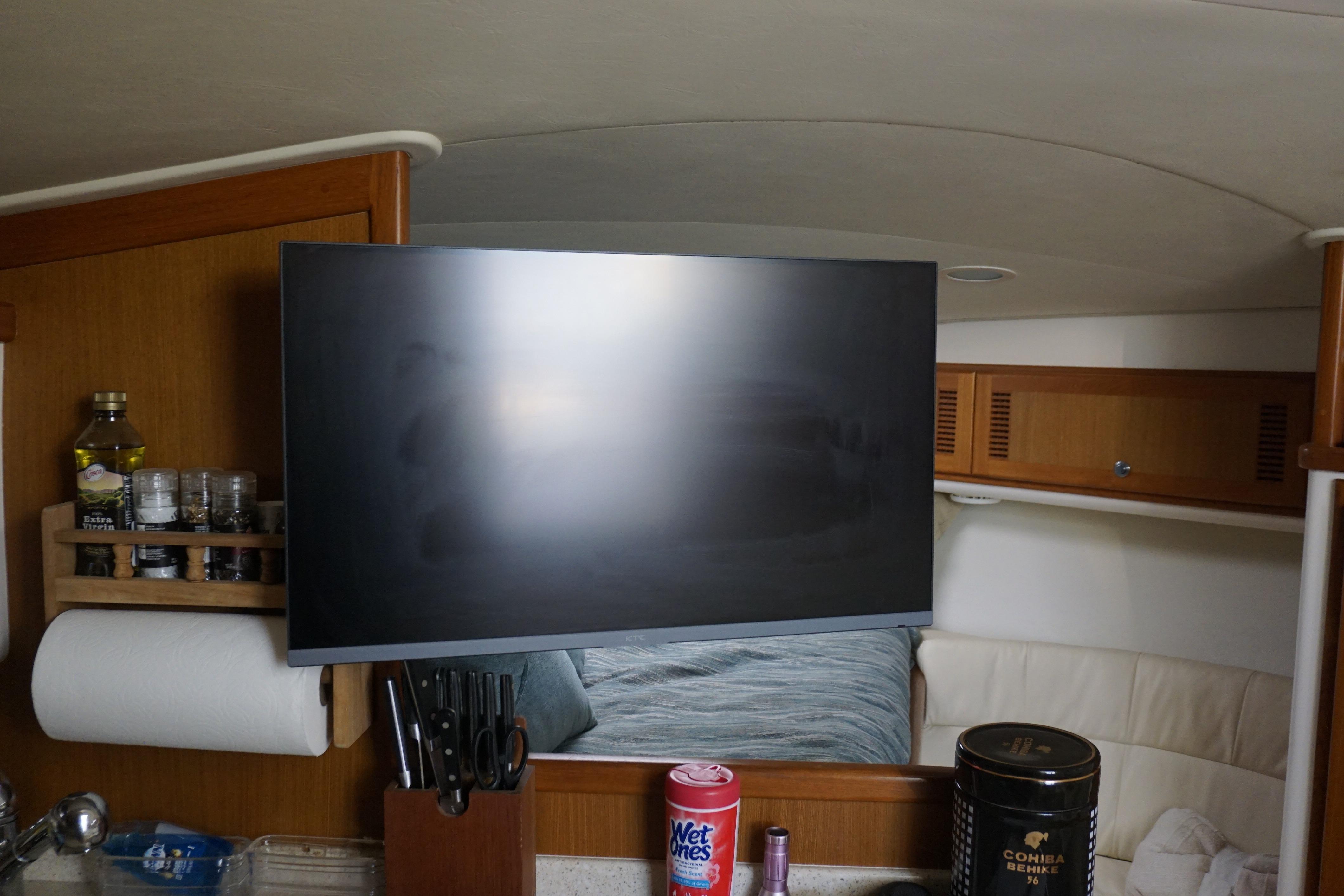 Interior of 2005 Cabo 35 Express boat with TV, kitchen items, and seating area.