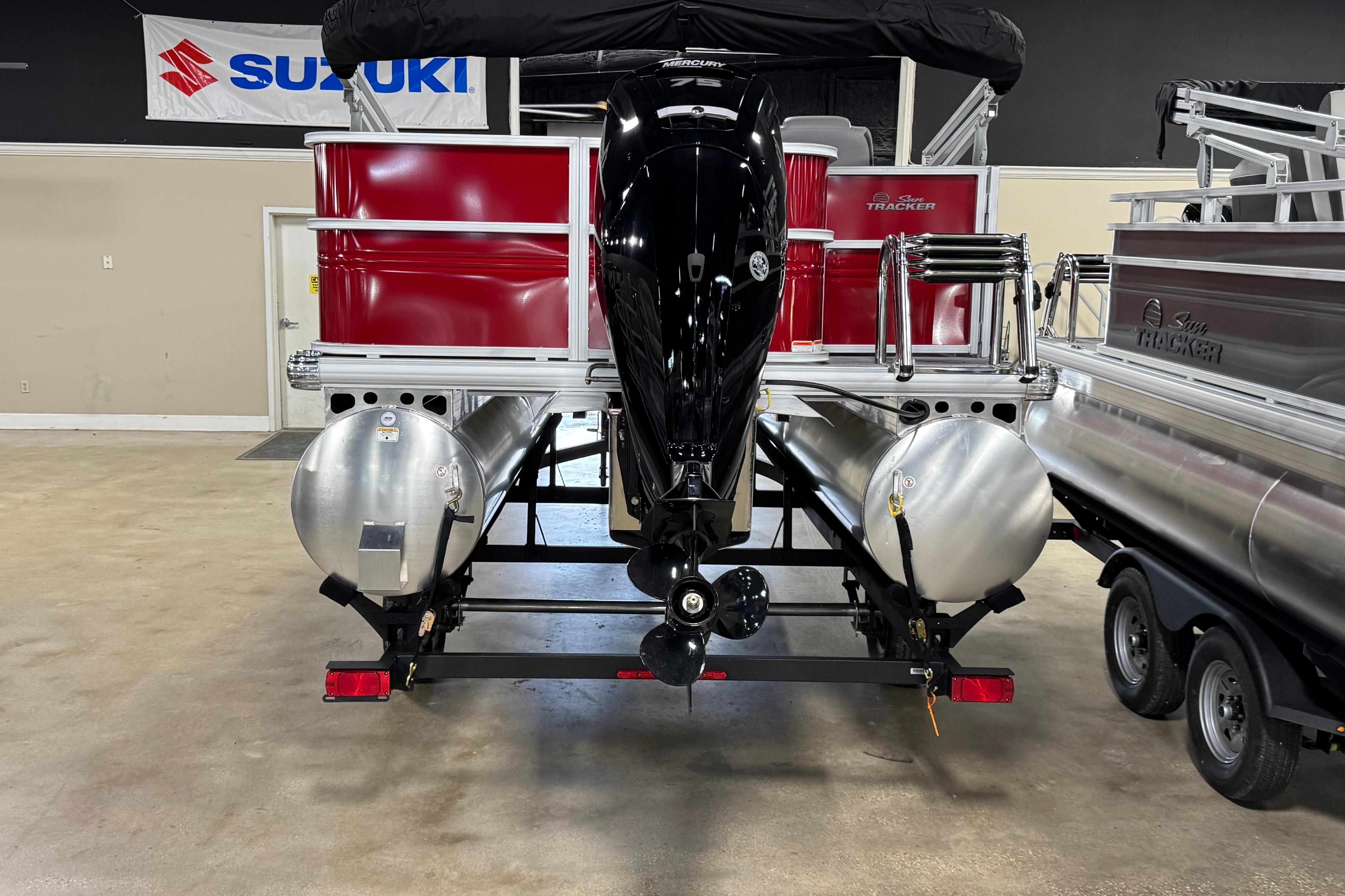 2026 Sun Tracker Party Barge 18 DLX pontoon boat in showroom, rear view.