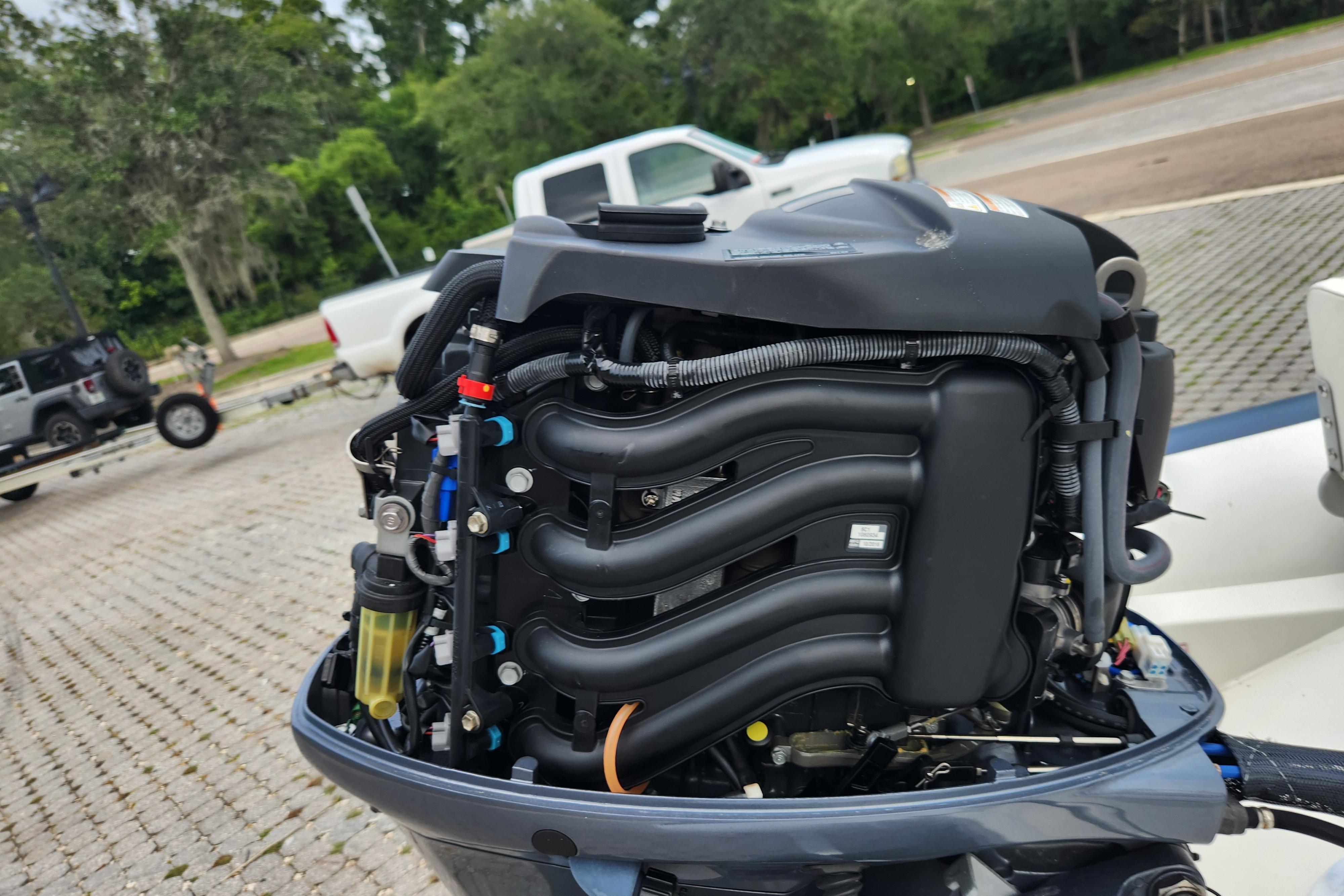 2019 Novurania DL 400 boat engine, detailed view, outdoors with vehicles in background.