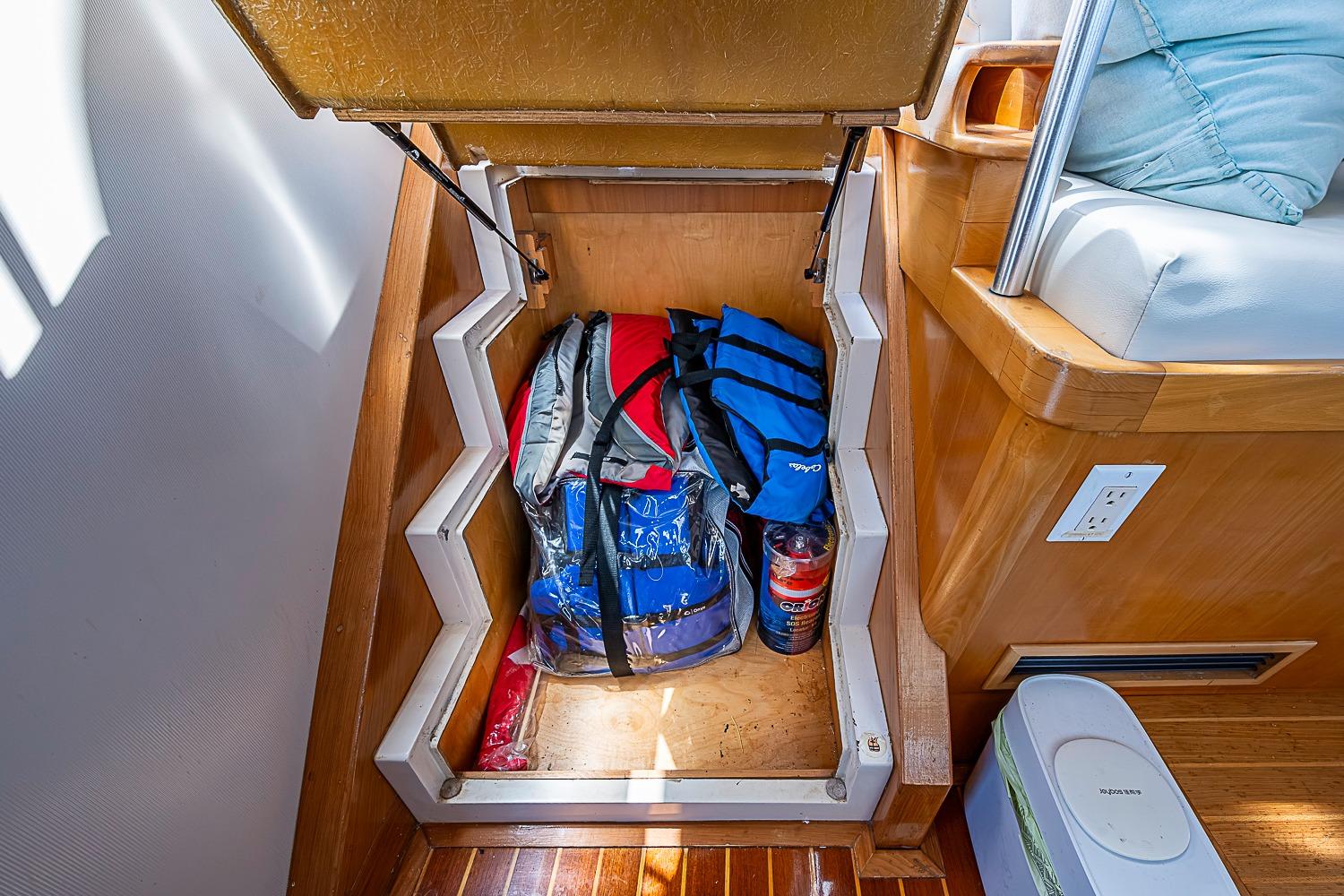 Storage compartment on 2003 Magna Marine Nova Scotia 47 boat with bags and a bottle.