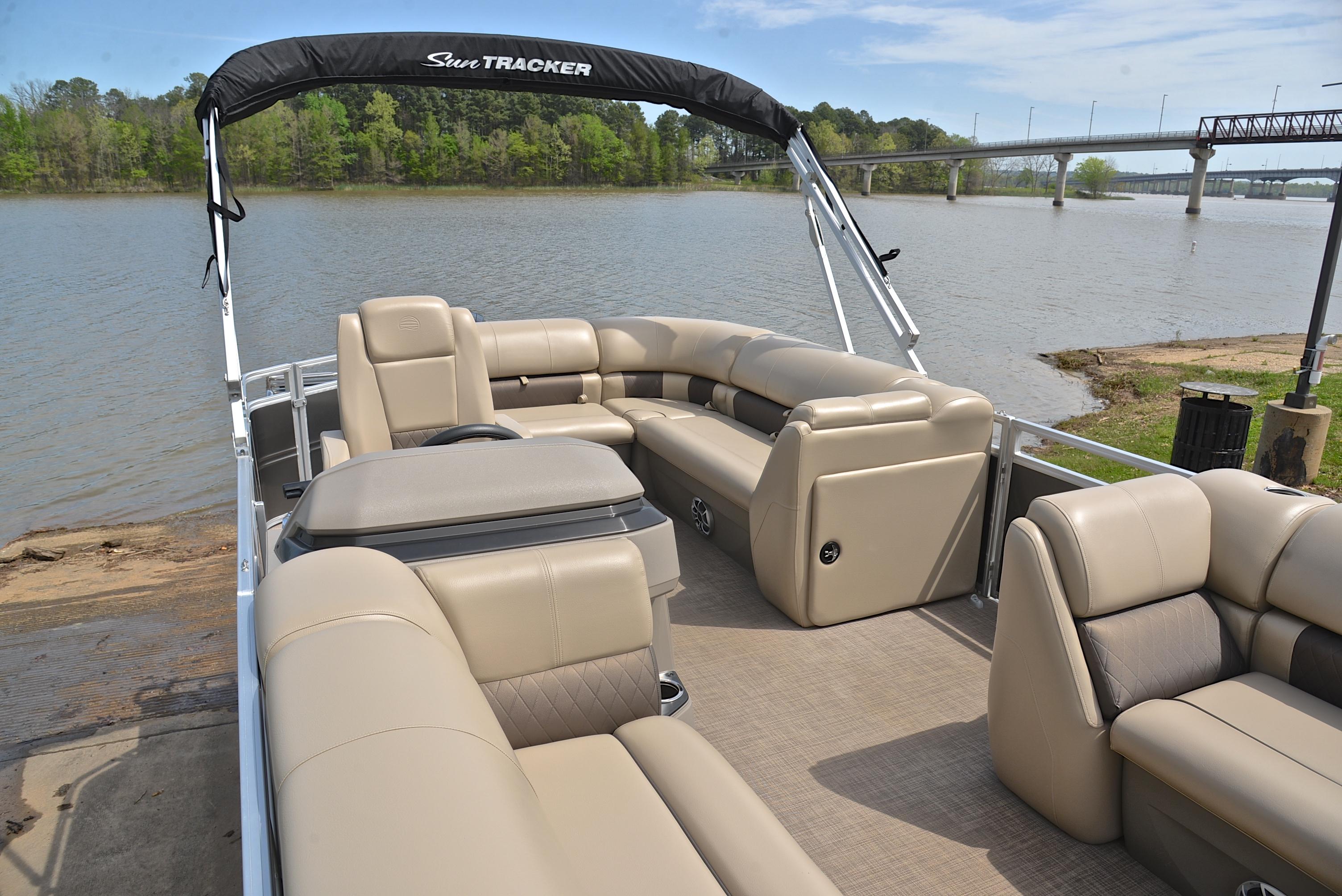 2024 Sun Tracker Party Barge 20 DLX pontoon boat on a scenic lake.