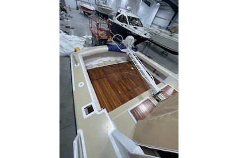 1964 Striker Model 120 boat with wooden deck in a storage facility.