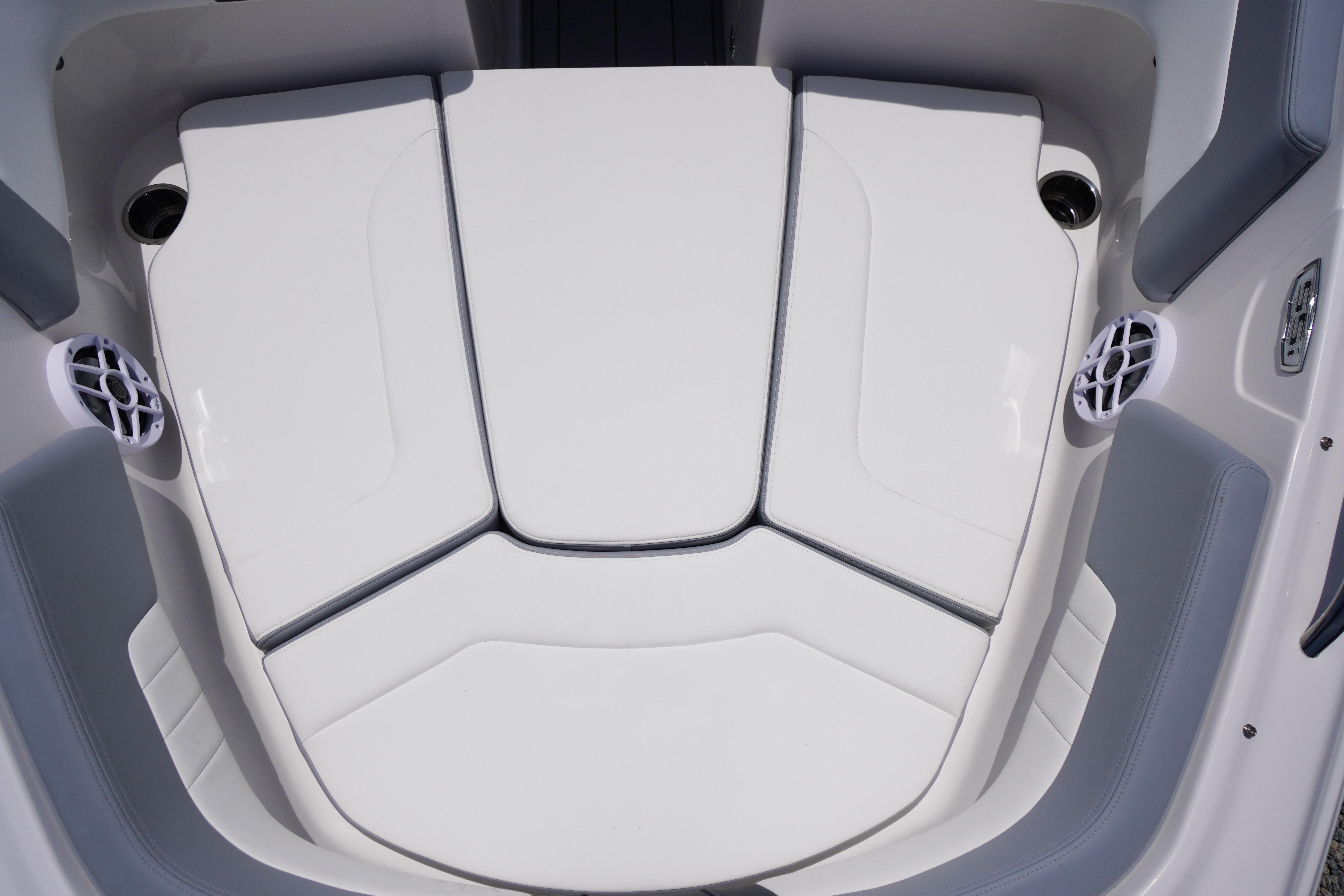2026 Chaparral 23 SSi OB boat interior seating with white cushions and integrated speakers.