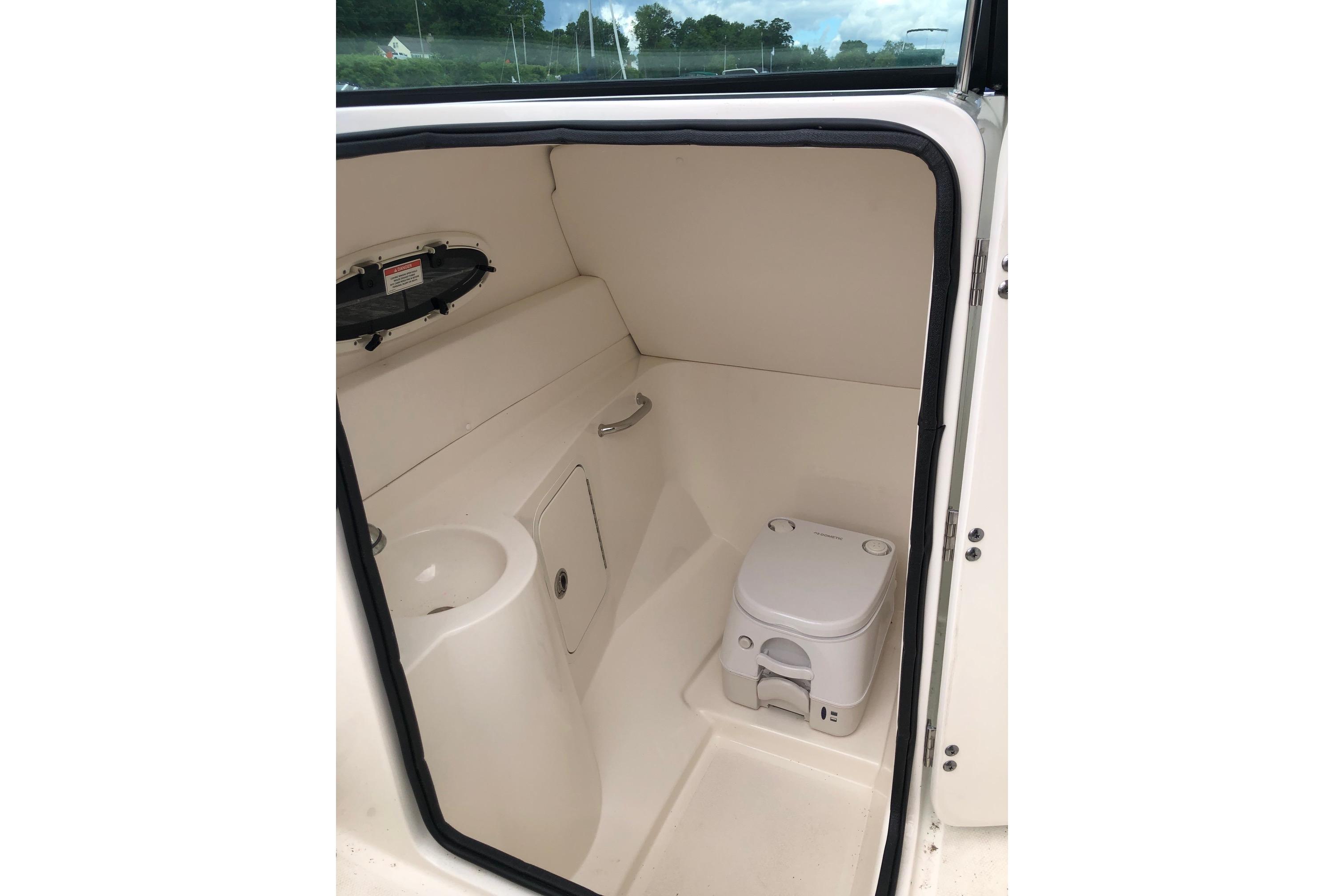 2013 Sea Ray 260 Sundeck interior with compact marine toilet and sink.