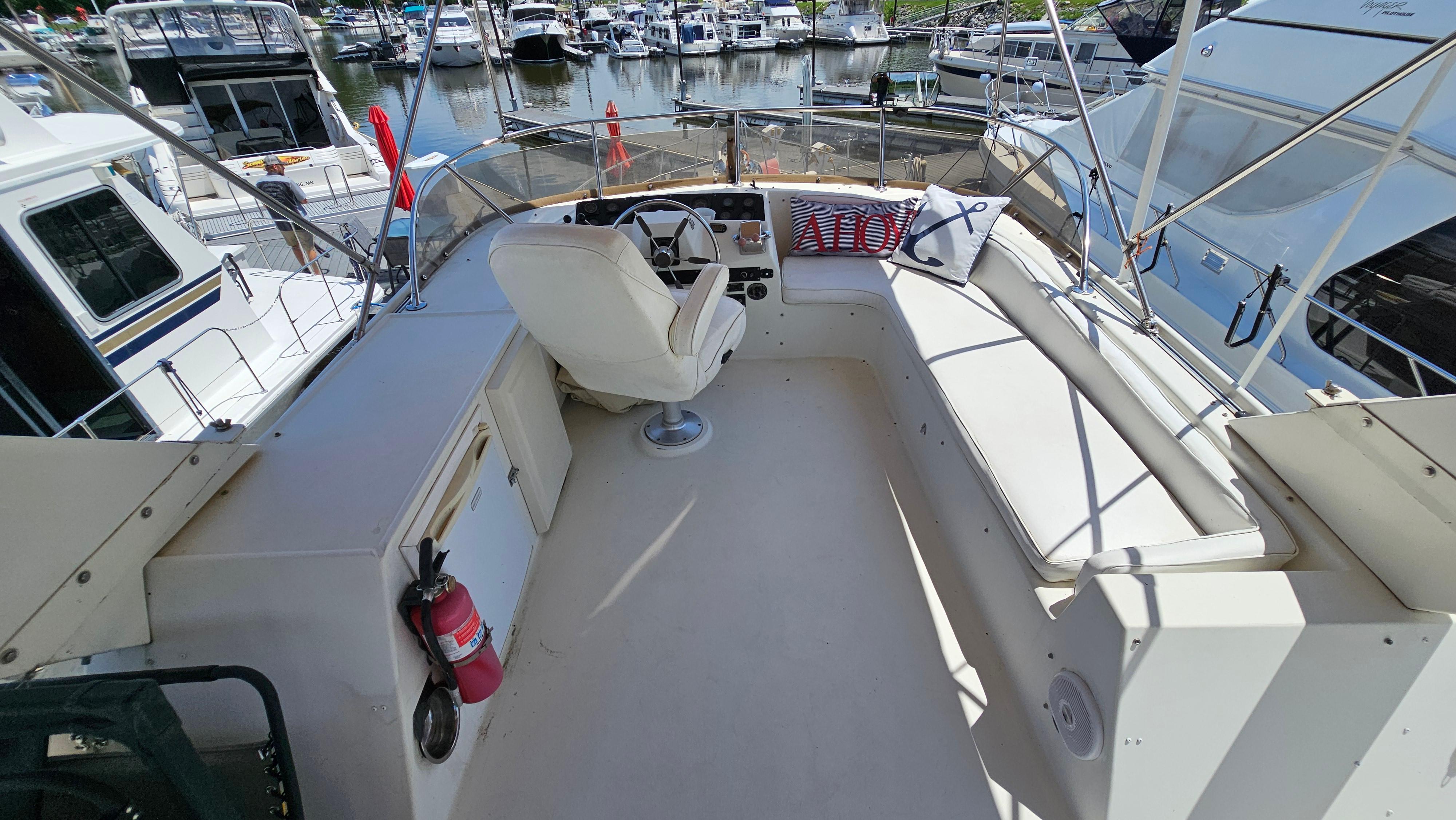 1988 Bluewater Yachts 55 Coastal Cruiser helm with seating, docked at marina.
