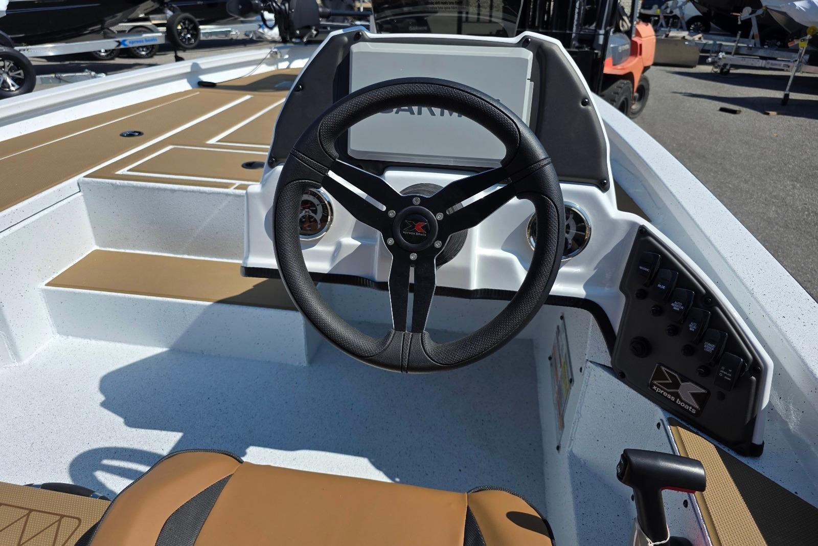 2026 Xpress H20C Crappie boat interior with steering wheel and control panel.