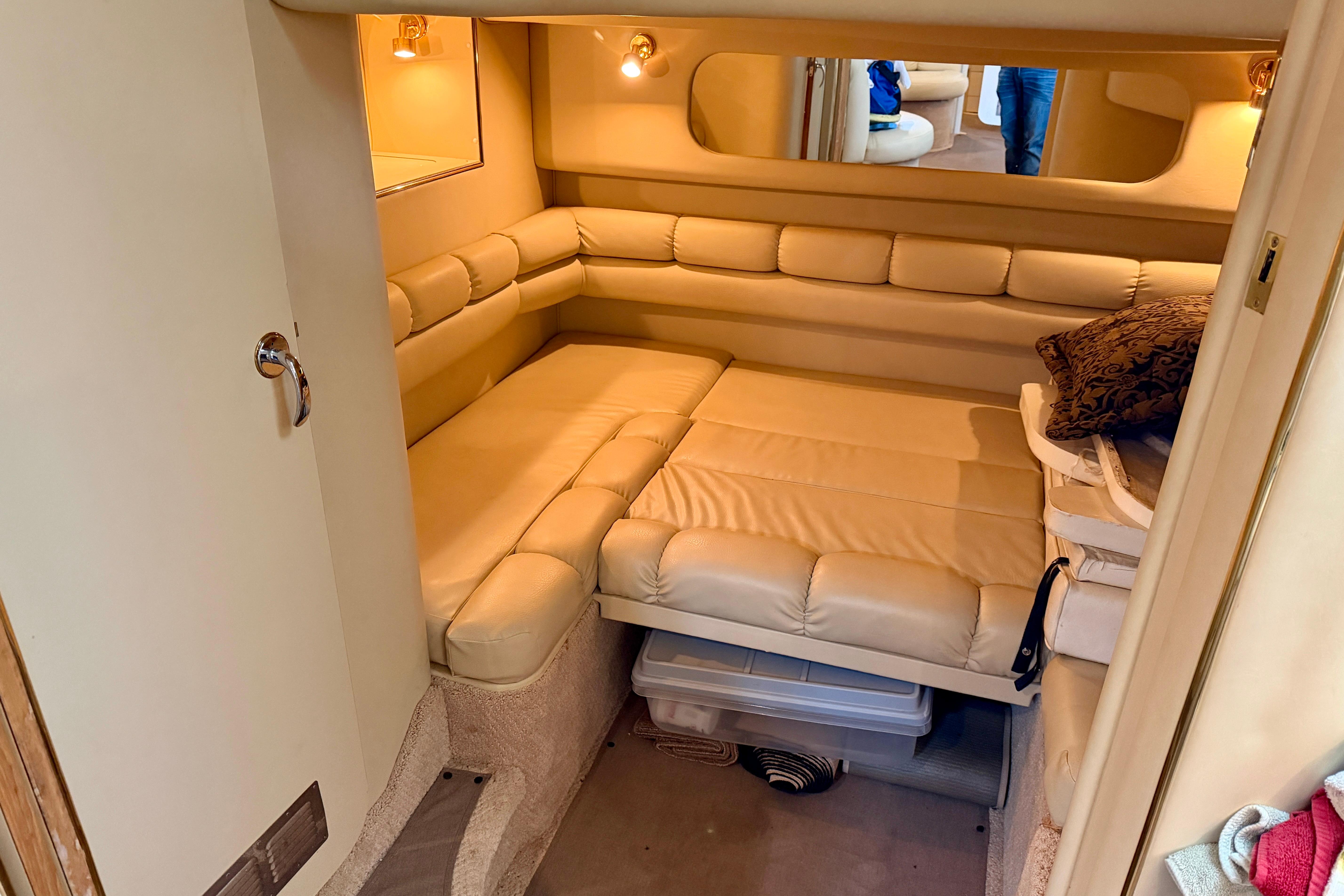1999 Sea Ray 400 Sundancer cabin interior with beige leather seating and cozy lighting.