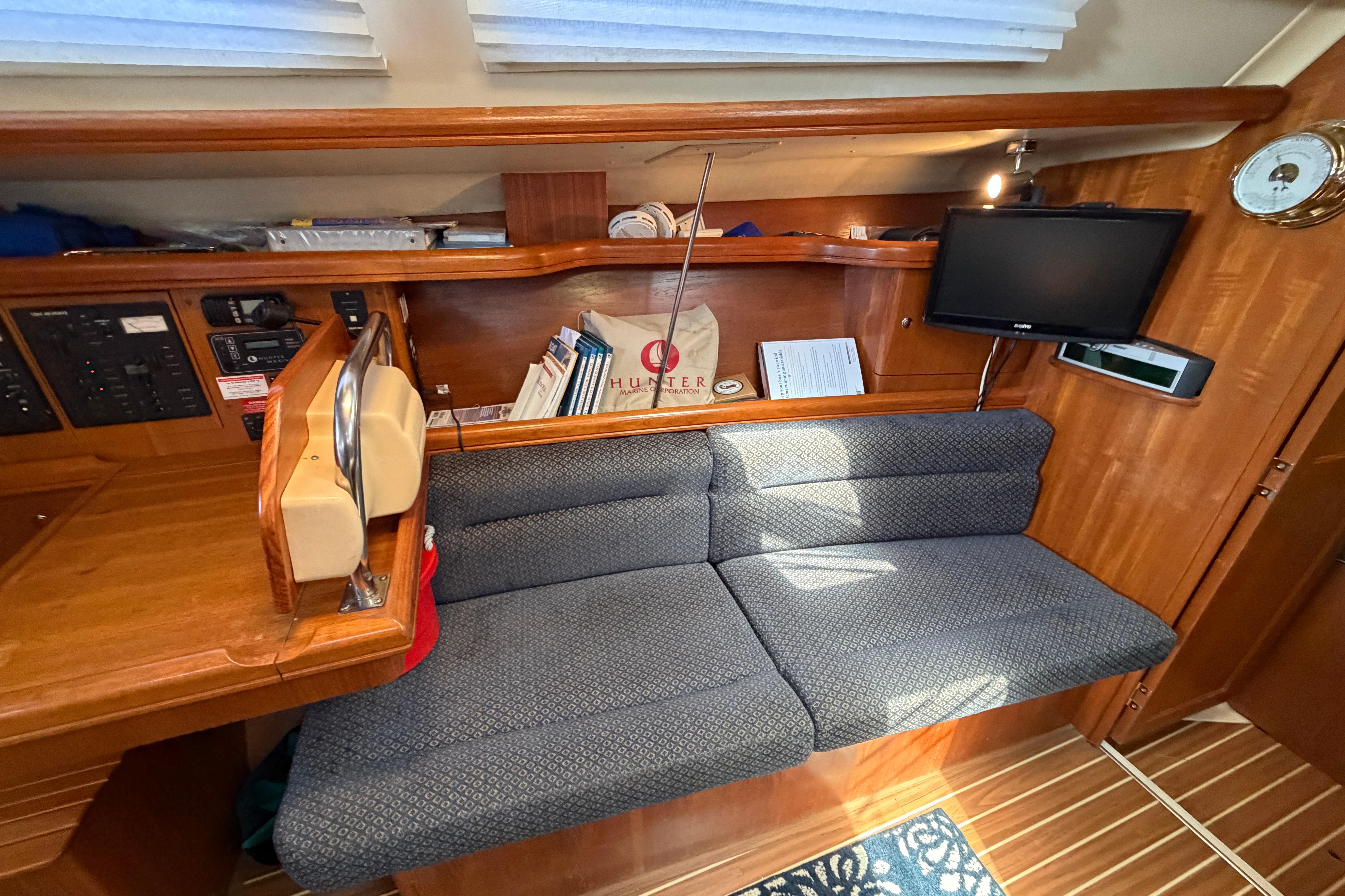 Interior of a 2005 Hunter 38 sailboat with seating, TV, and navigation equipment.