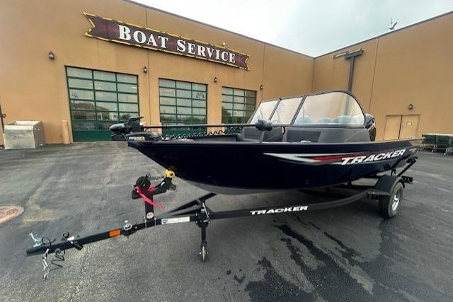 2026 Tracker Pro Guide V-16 WT boat on trailer outside service center.