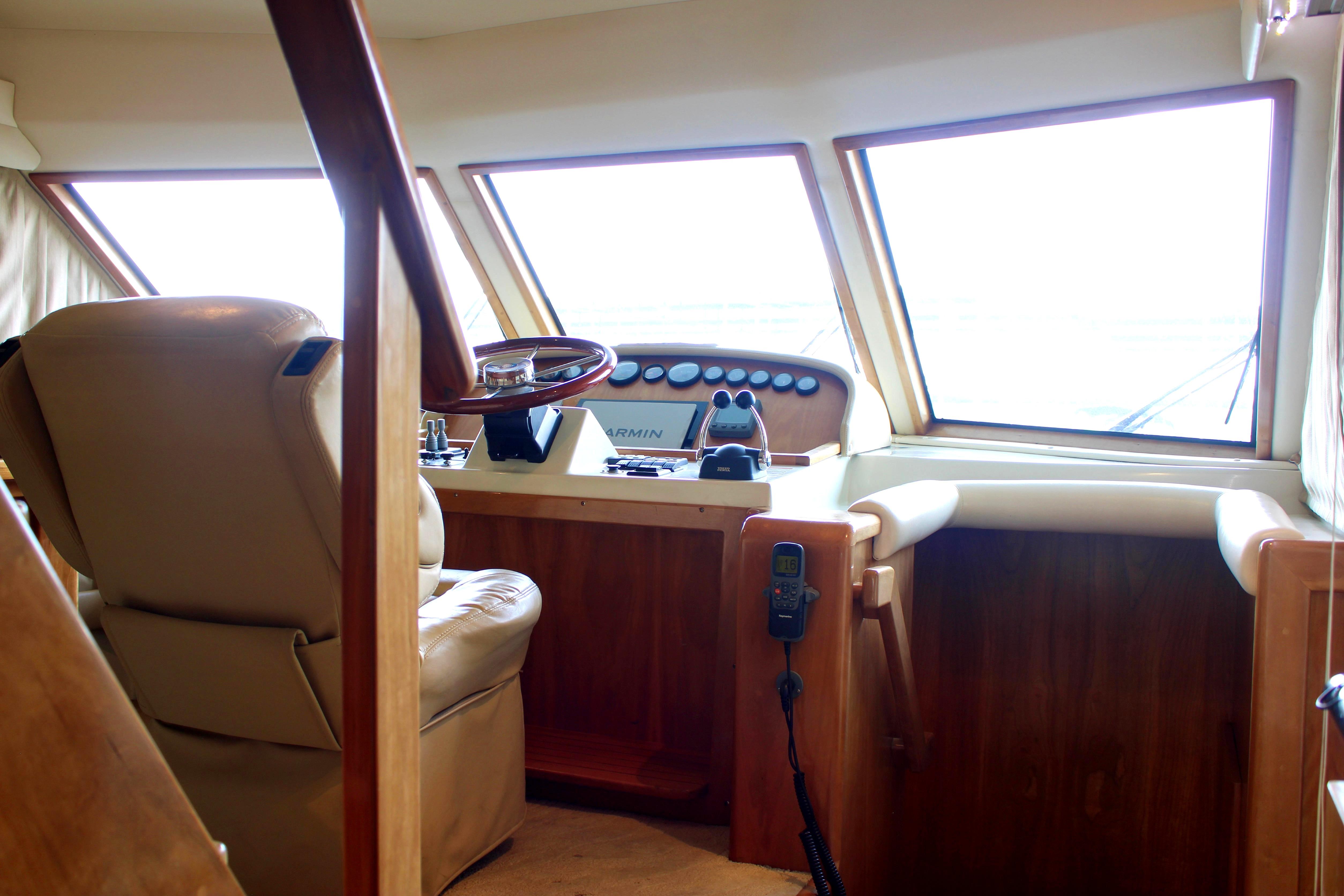 Interior of 2007 Navigator 5100 yacht helm with leather seat and navigation controls.