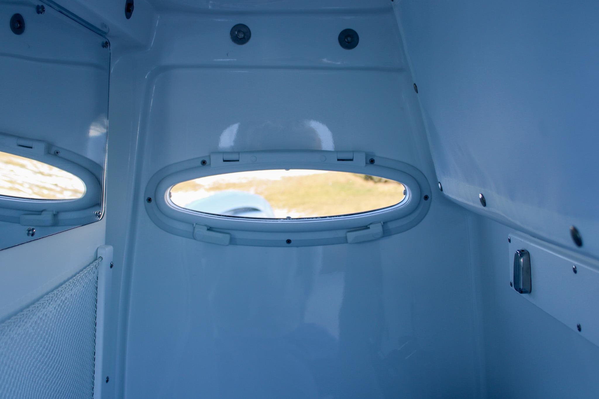 Interior view of 2026 Sea Hunt Gamefish 25 boat cabin with oval window.