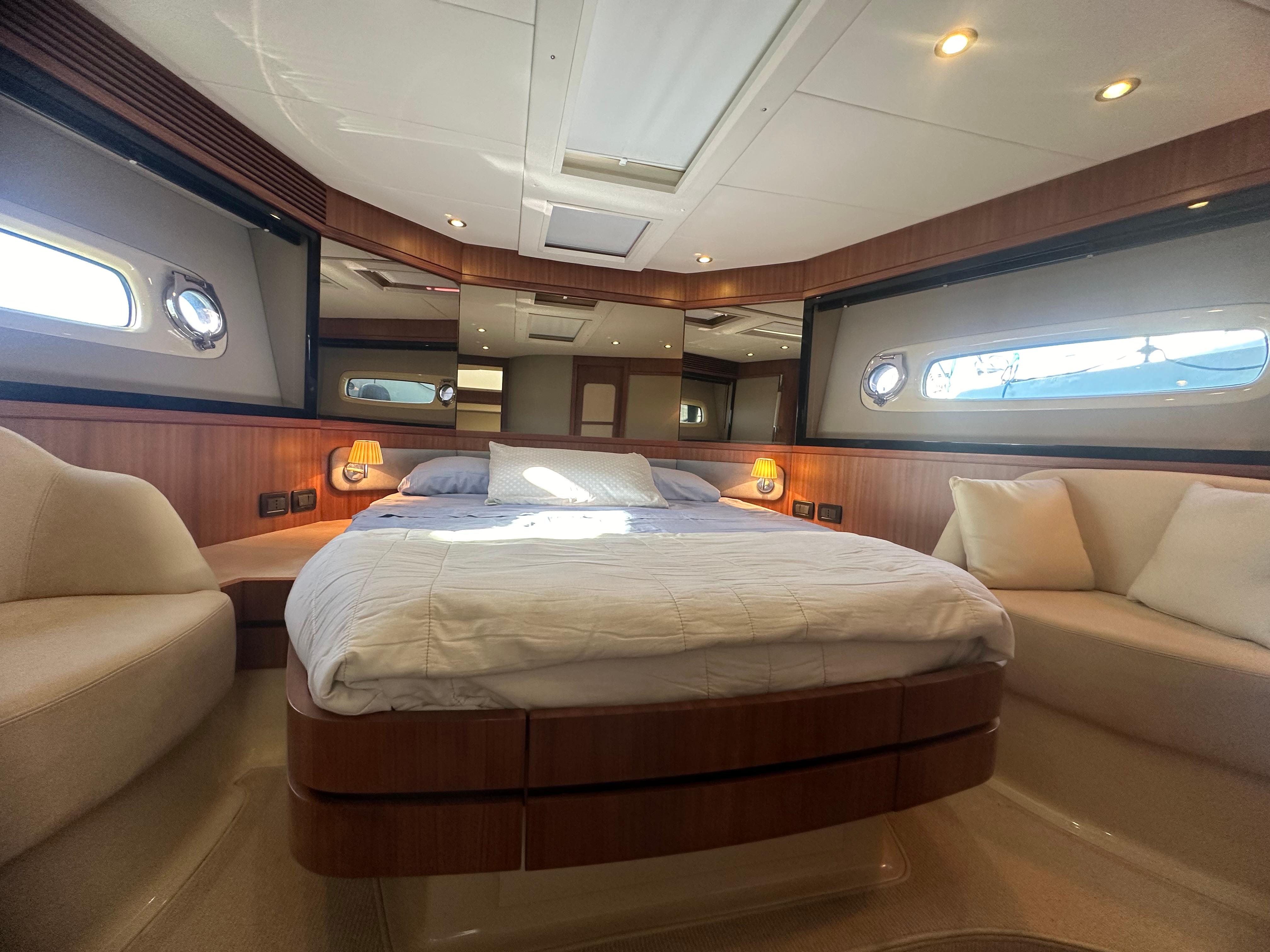 Luxurious bedroom interior of 2014 Azimut Magellano 50 yacht with elegant wood finishes.