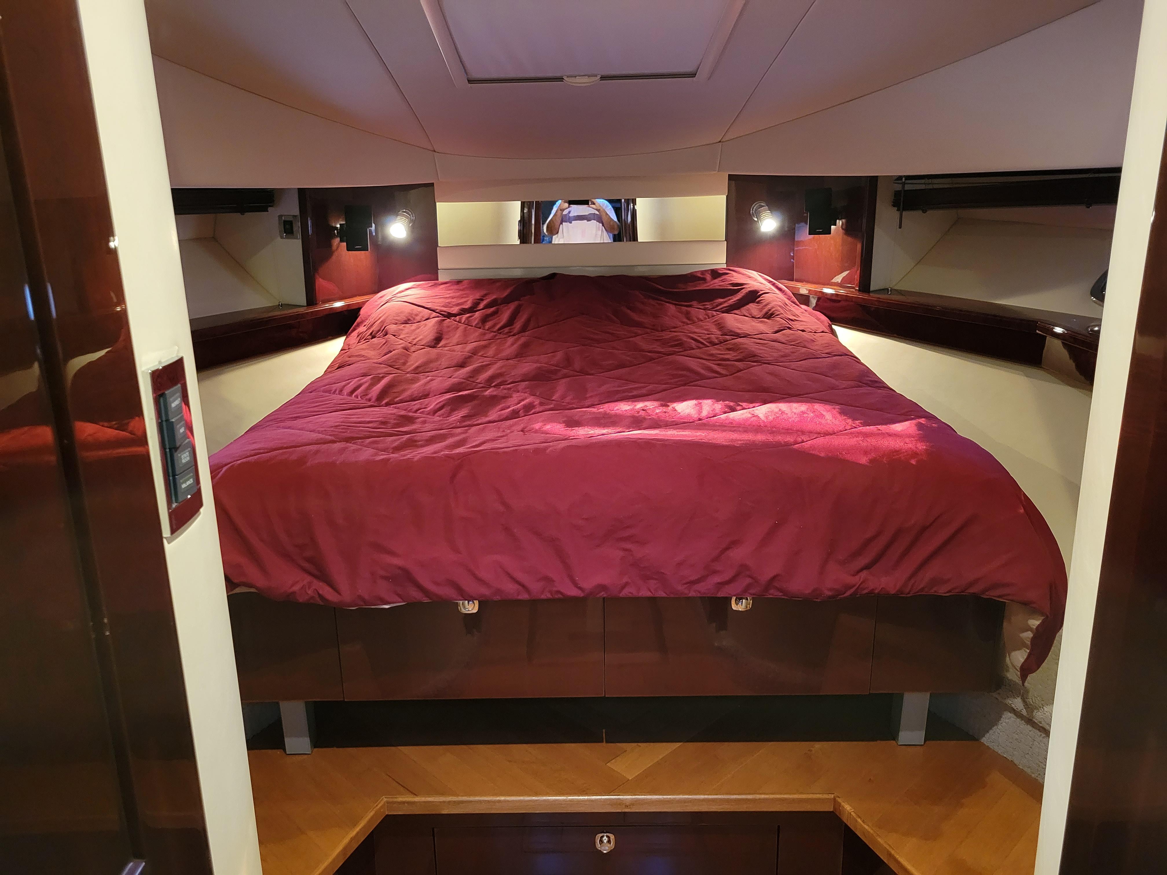 Luxurious cabin interior of 2009 Sea Ray 500 Sundancer with cozy bed and ambient lighting.