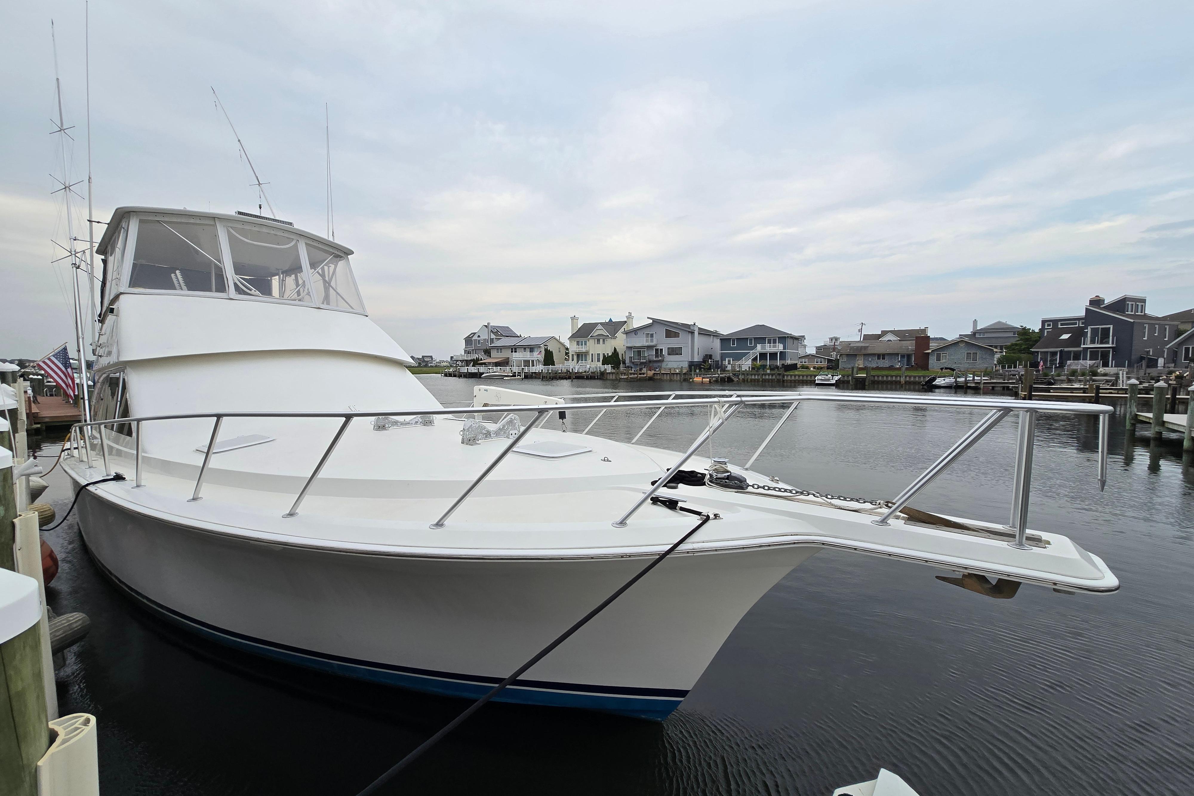2001 Cavileer 53 Convertible yacht docked in a serene marina setting.