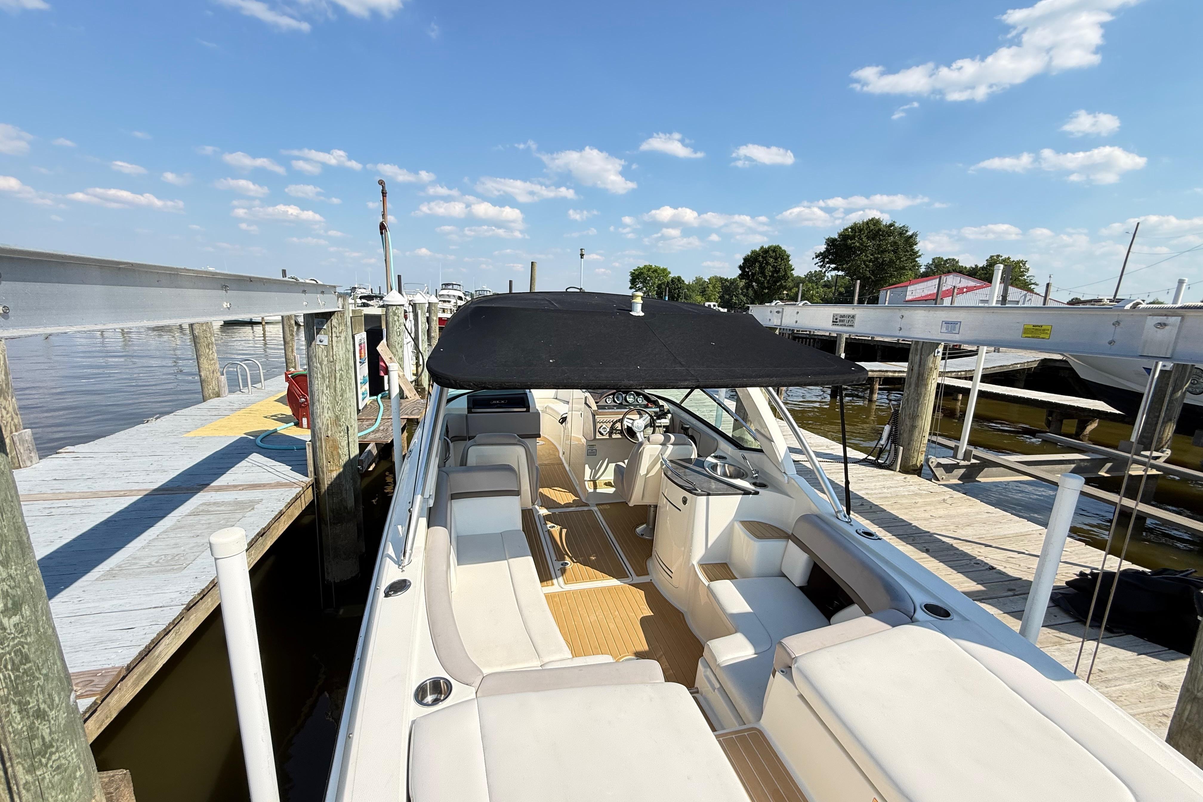 2011 Sea Ray 270 SLX boat docked, featuring spacious seating and a black canopy.