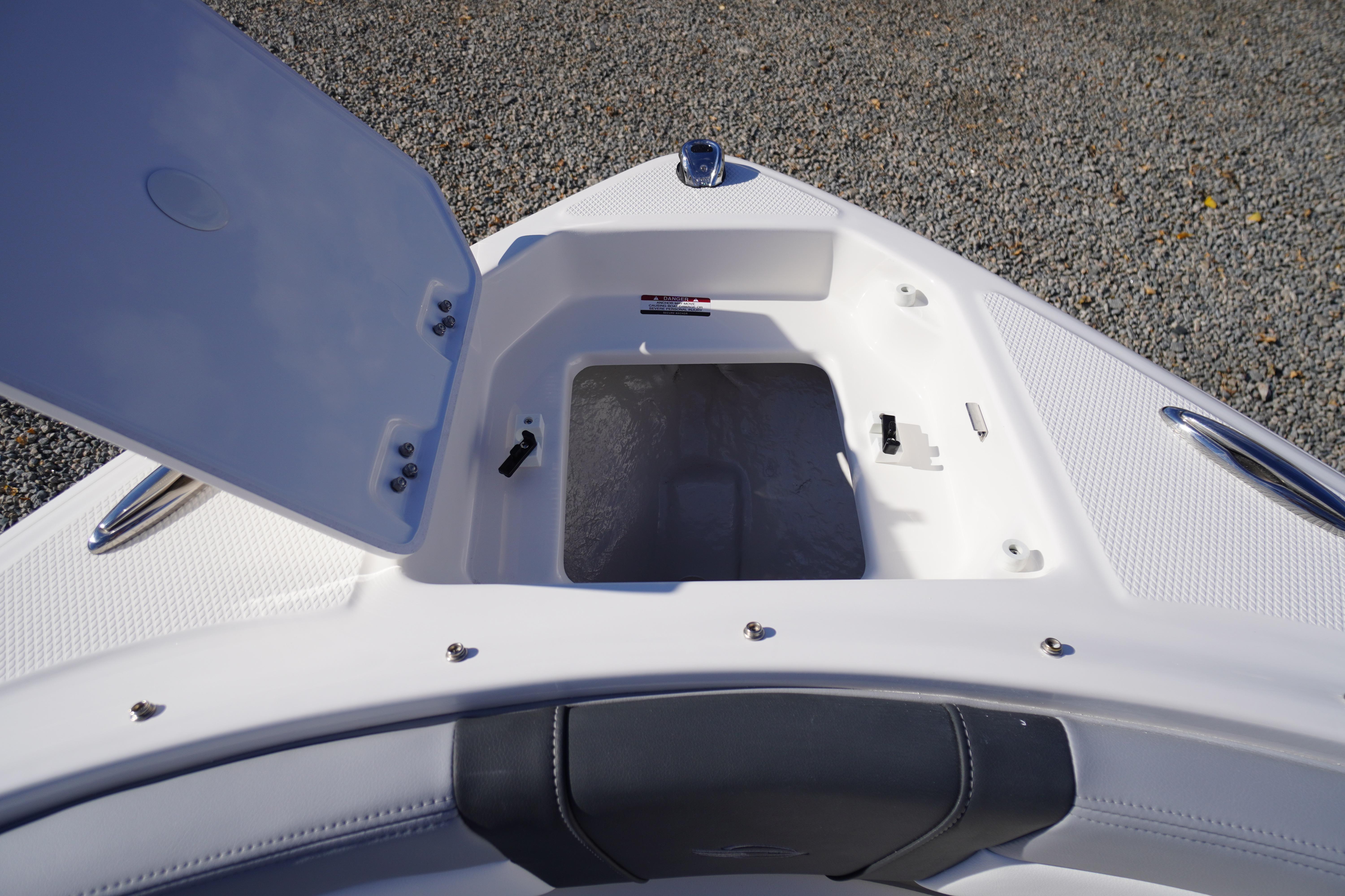 Open storage compartment on 2026 Chaparral 23 SSi OB boat, showing interior details.
