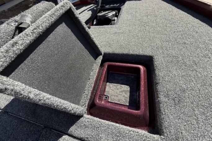 2026 Nitro Z21 XL Pro boat storage compartment with open lid, showcasing carpeted interior.