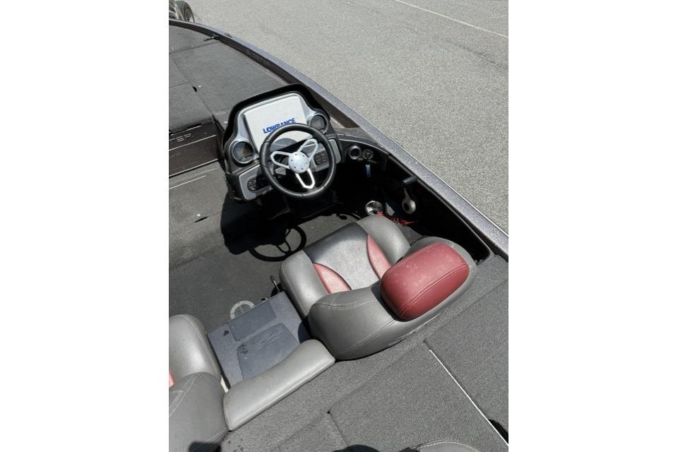 2013 Skeeter FX21 boat interior with steering wheel and red-gray seating.