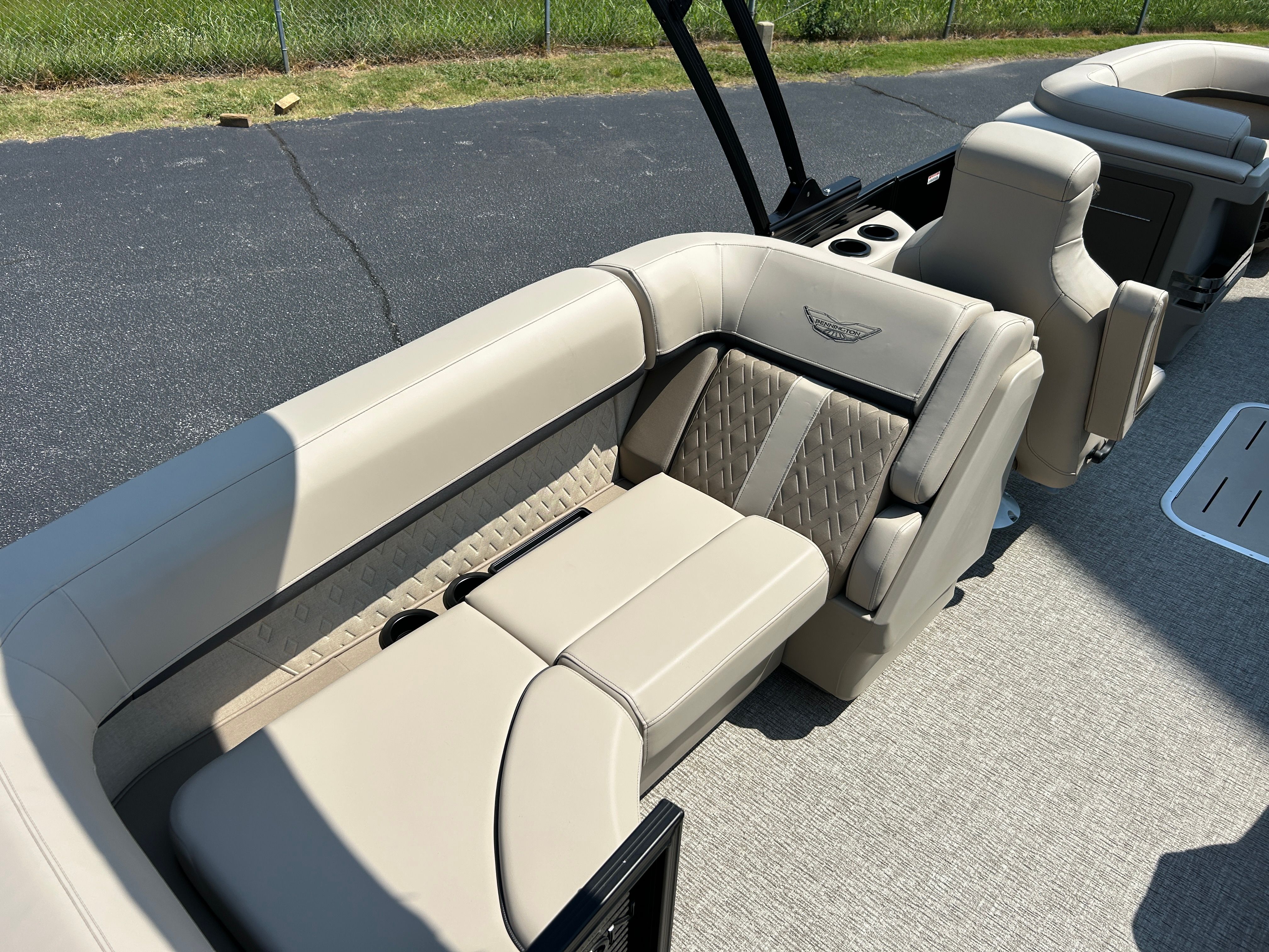 Interior of a 2026 Bennington 22 MFB with beige upholstered seats and sleek details.