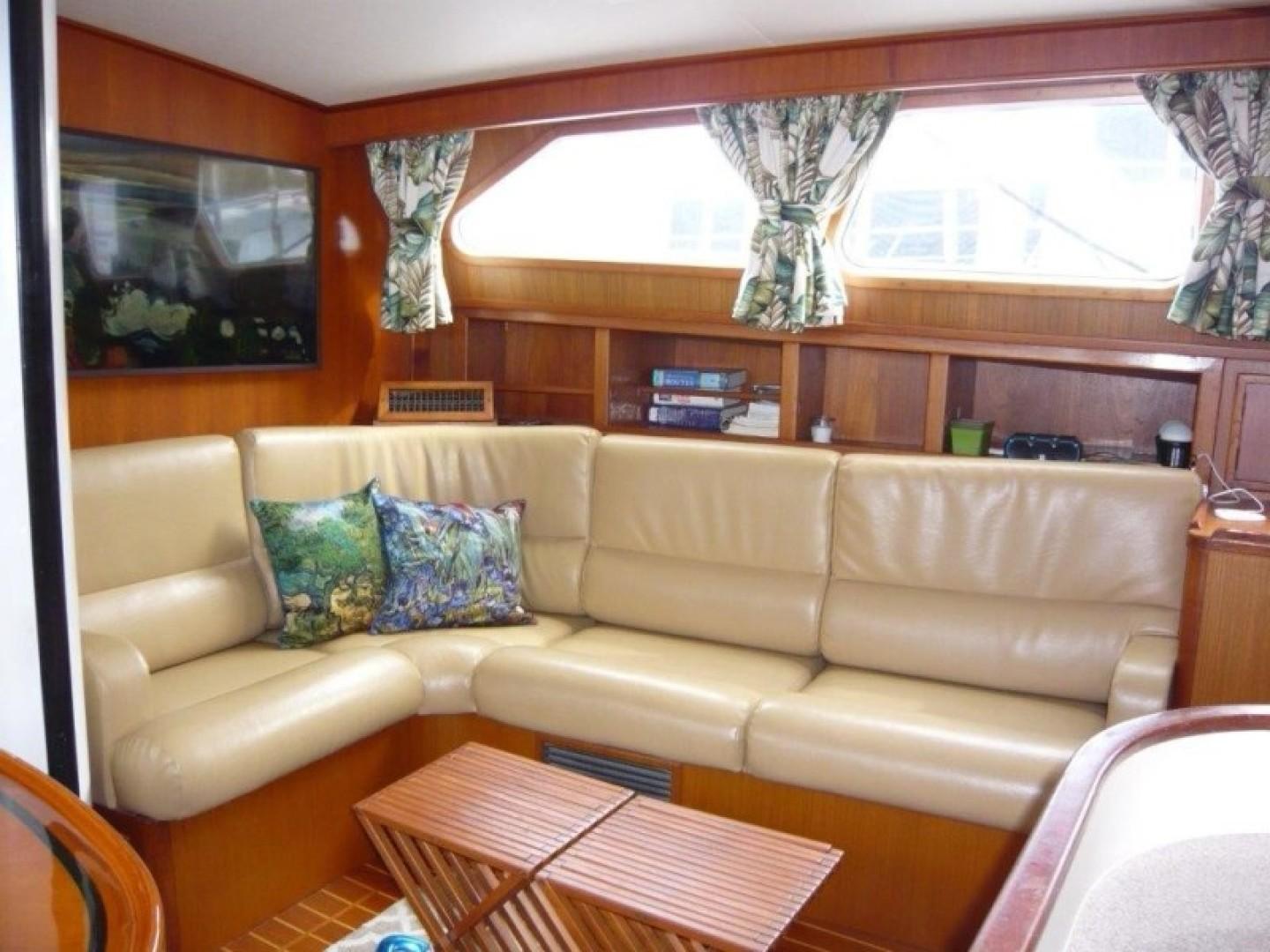 Interior of 1990 Cheoy Lee Sloop with beige leather seating and wooden accents.