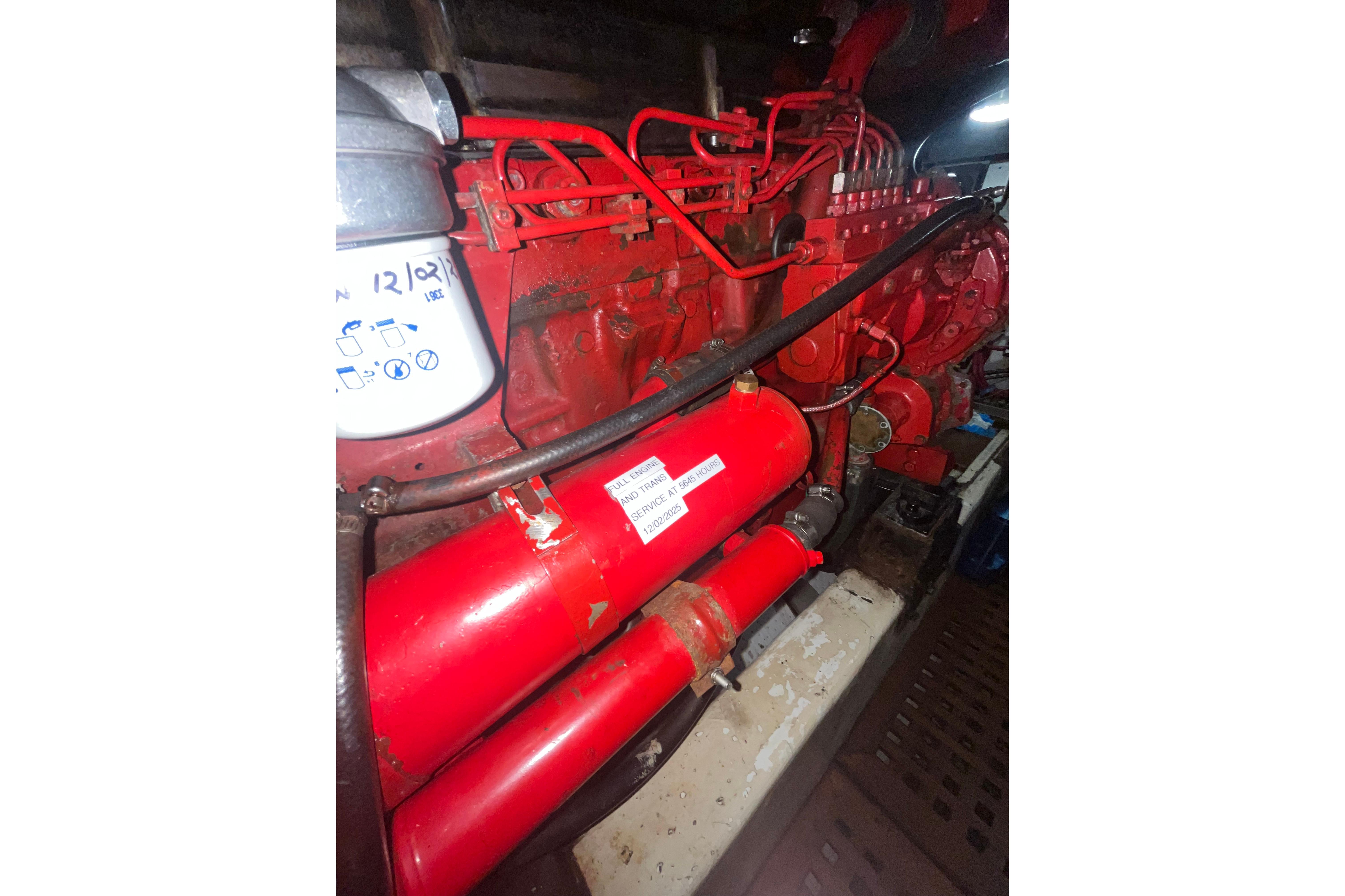Engine compartment of a 1986 Sea Ranger 47 Pilothouse, featuring red machinery components.