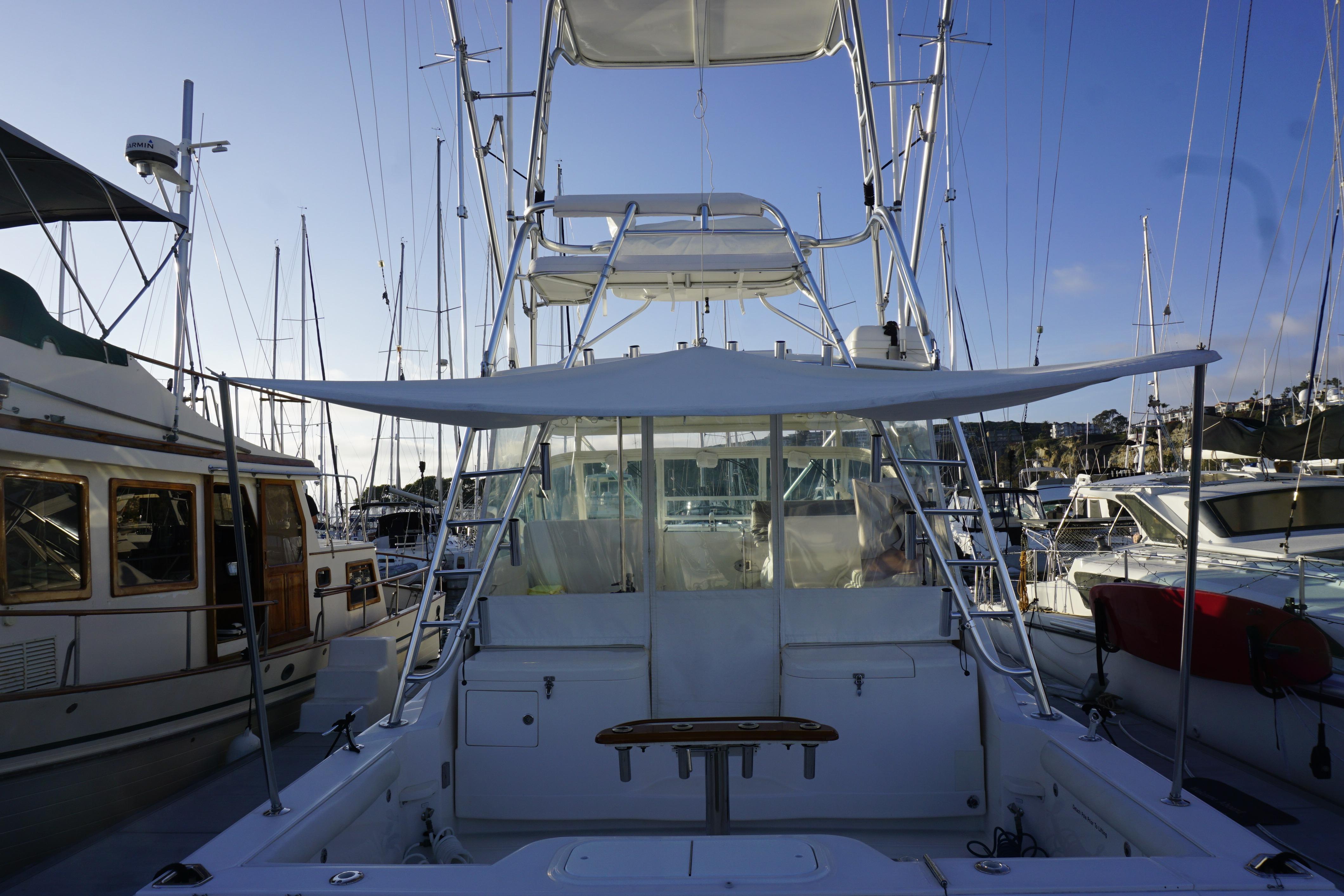 2005 Cabo 35 Express boat docked at marina, surrounded by other vessels.