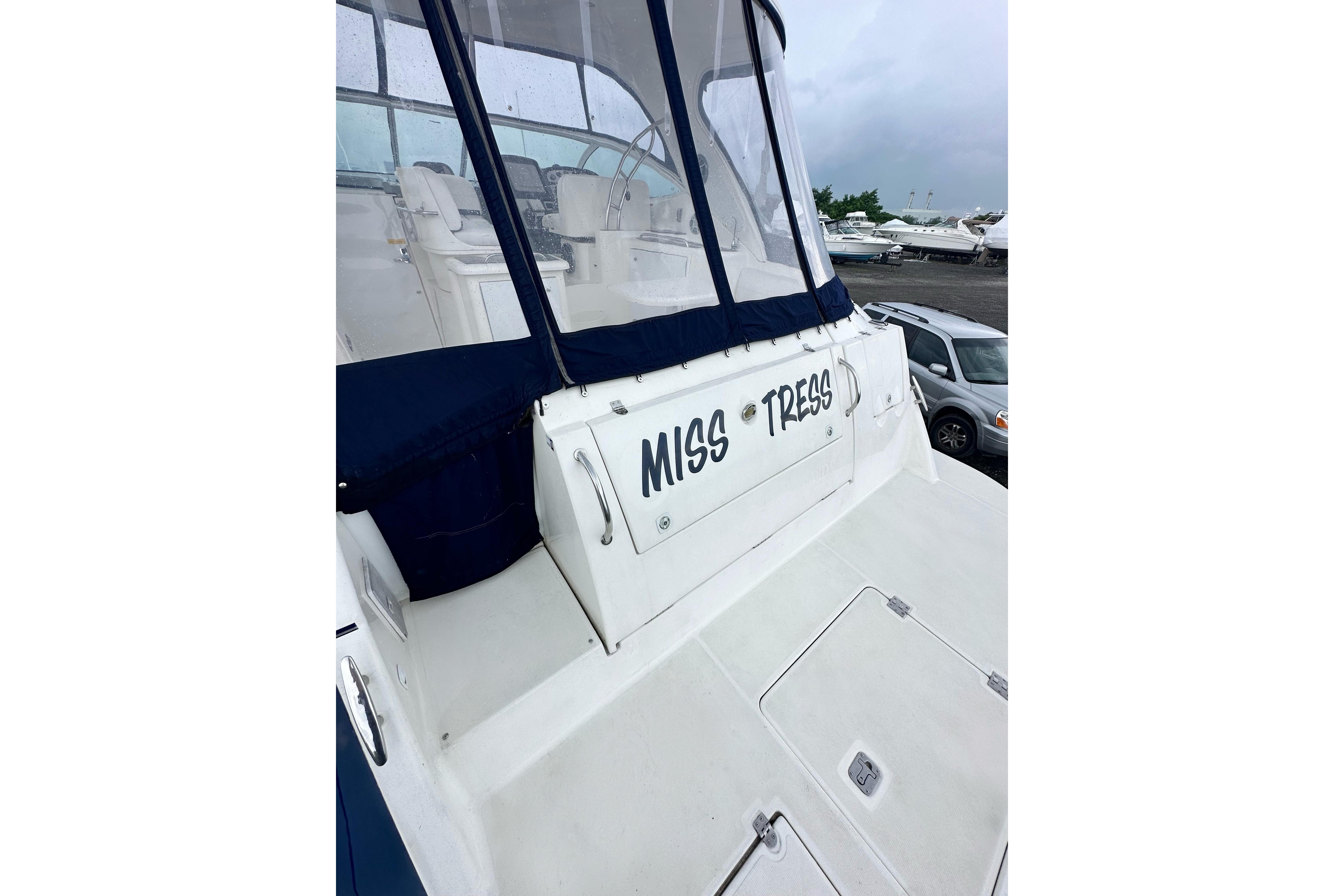 2006 Cruisers Yachts 420 Express with "MISS TRESS" name, docked in a marina.