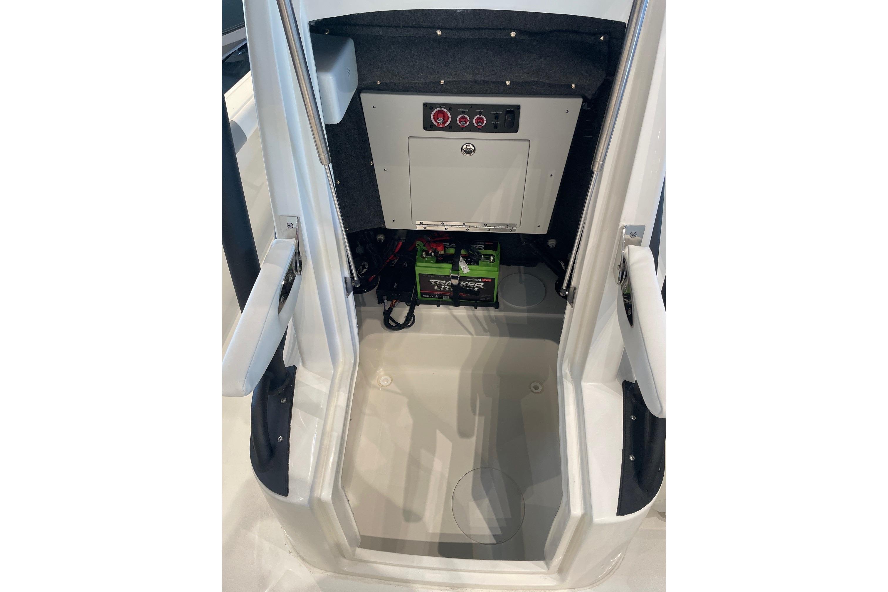 2026 Mako 24 APEX boat interior with battery compartment and control panel.