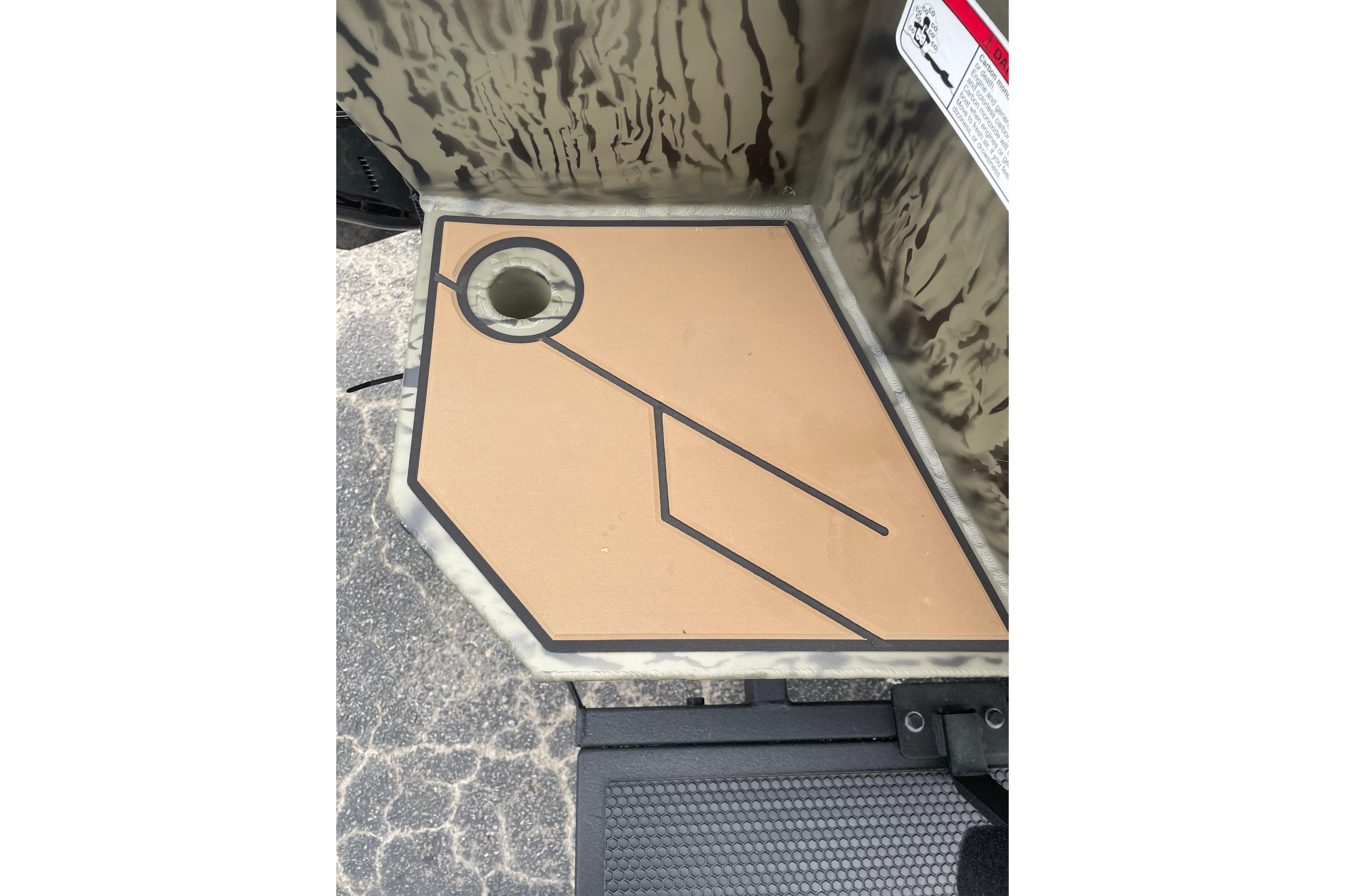 2026 Tracker Grizzly 1756 T Marsh boat deck with camouflage pattern and drainage hole.