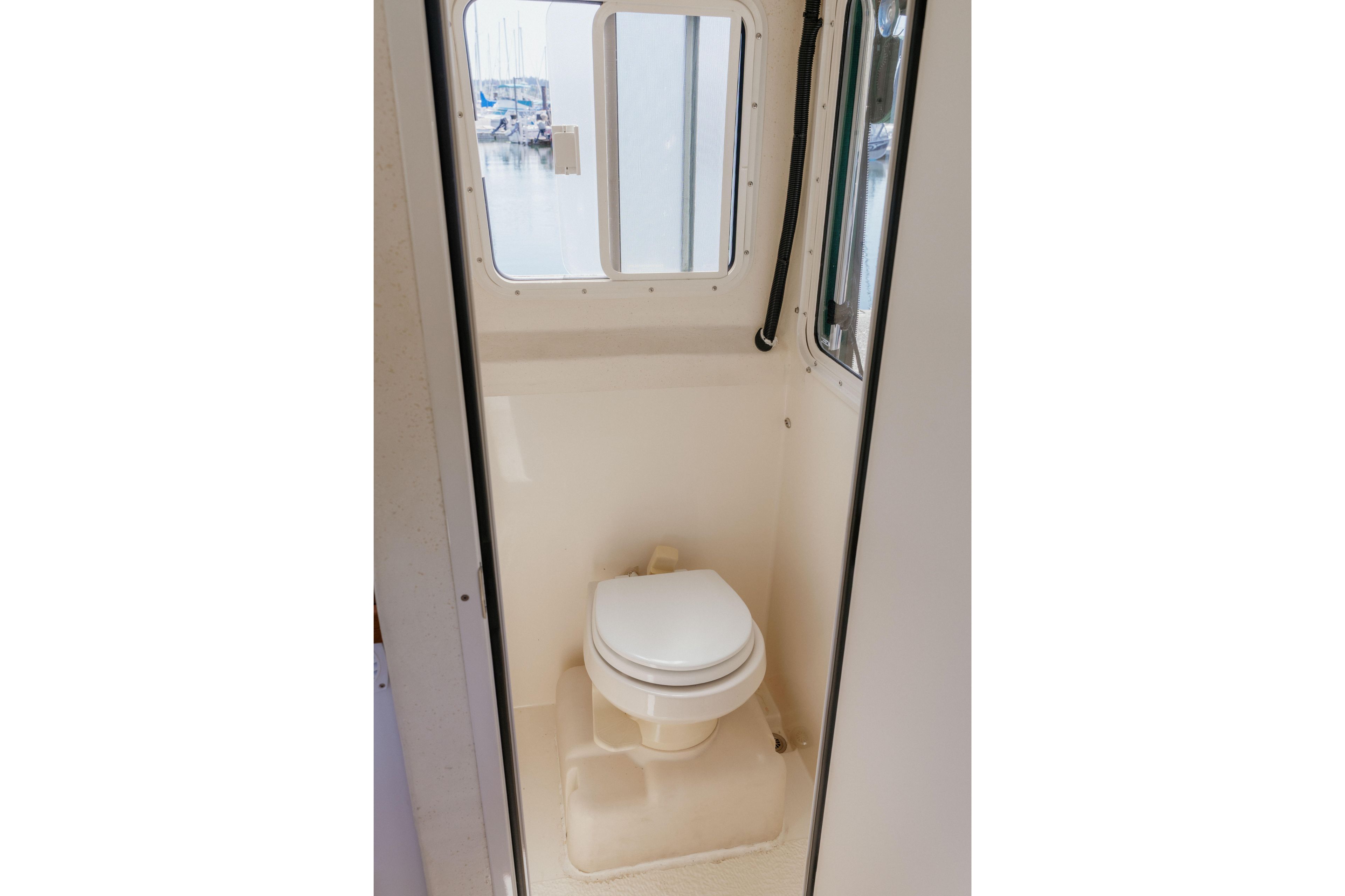 2006 C-Dory 25' Tomcat Catamaran bathroom interior with window view.
