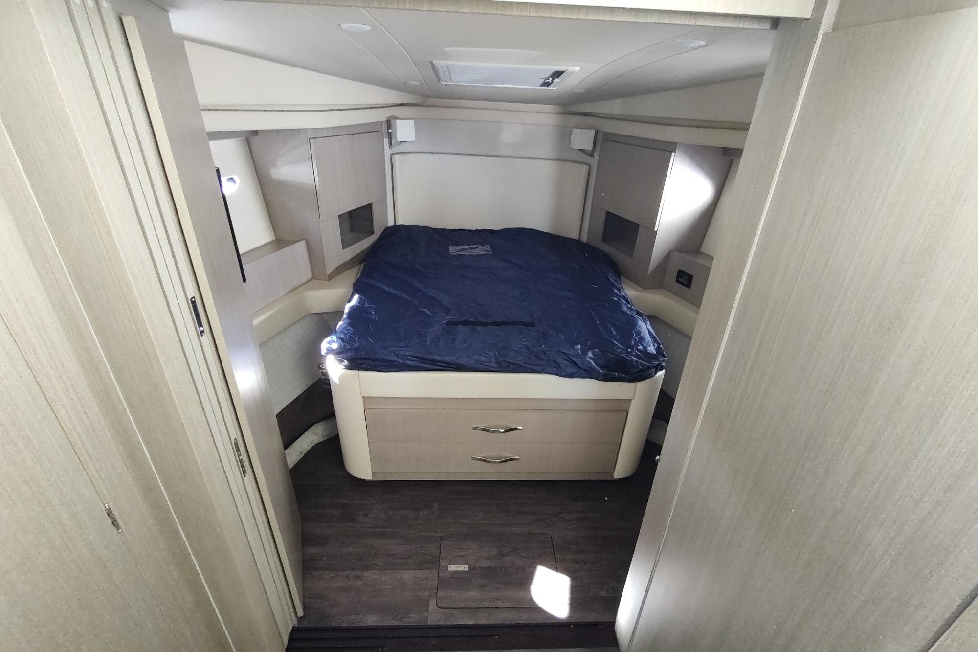 Luxurious cabin interior of 2021 Regal 42 Fly yacht with cozy bed and modern design.