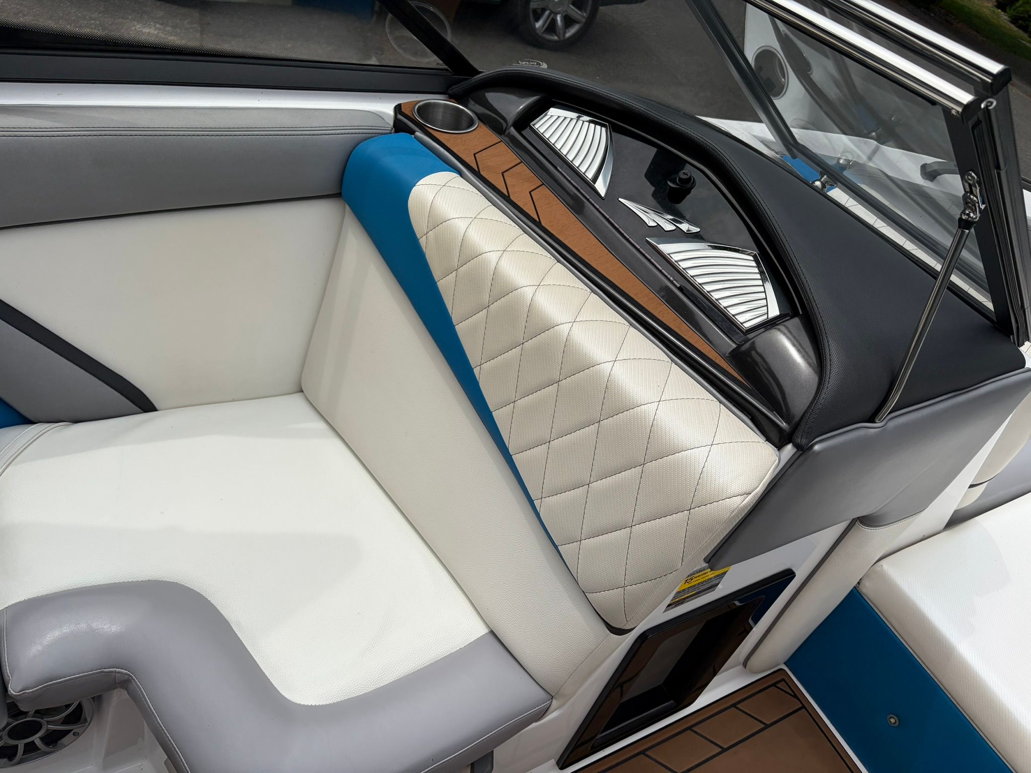 Interior of a 2016 Tigé RZ2 with white and blue upholstery and a cup holder.
