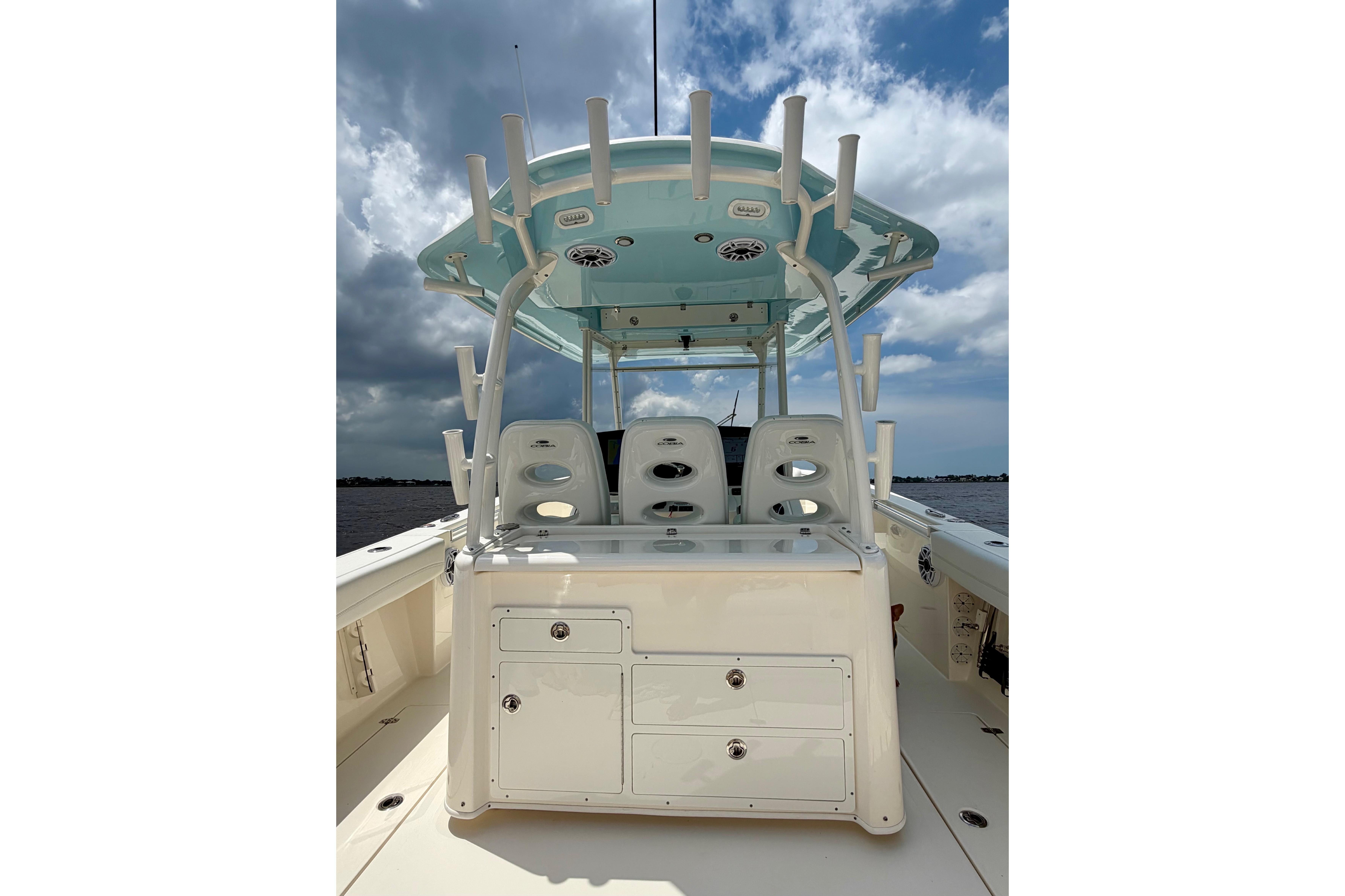 2023 Cobia 350 Center Console boat with sleek seating and storage, under a cloudy sky.