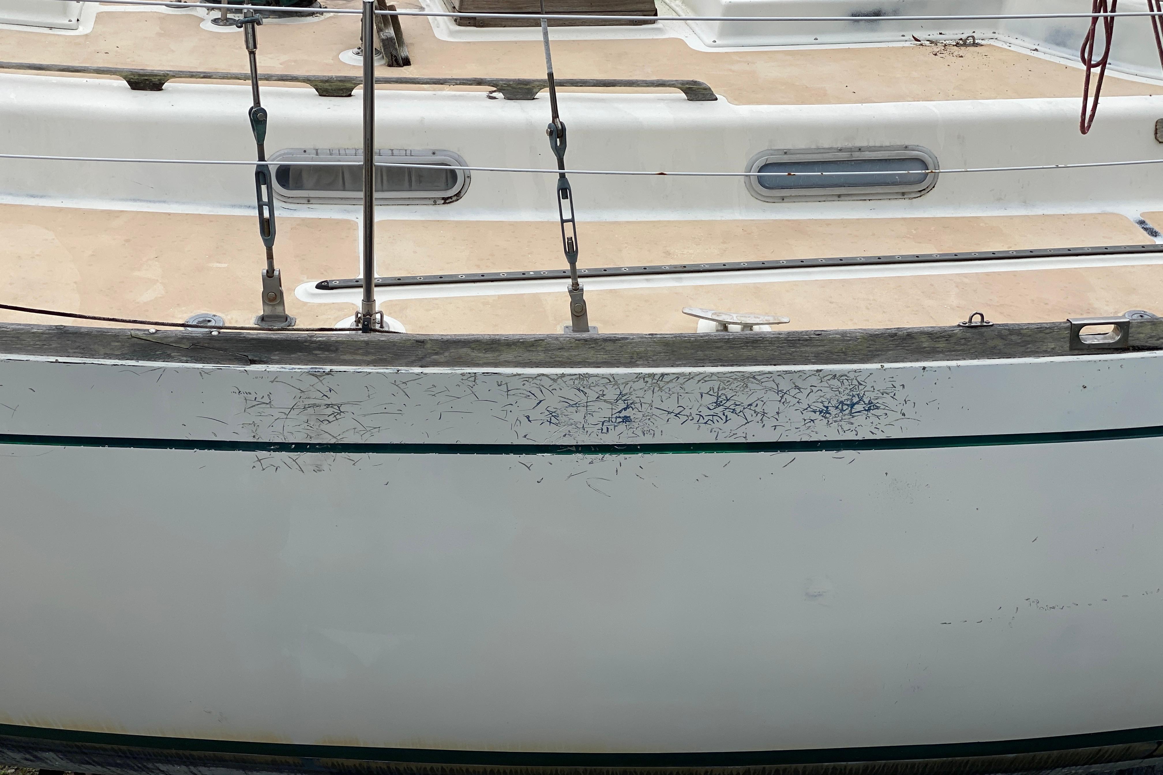 Side view of a 1979 Fuji 40 sailboat with visible scratches on the hull.