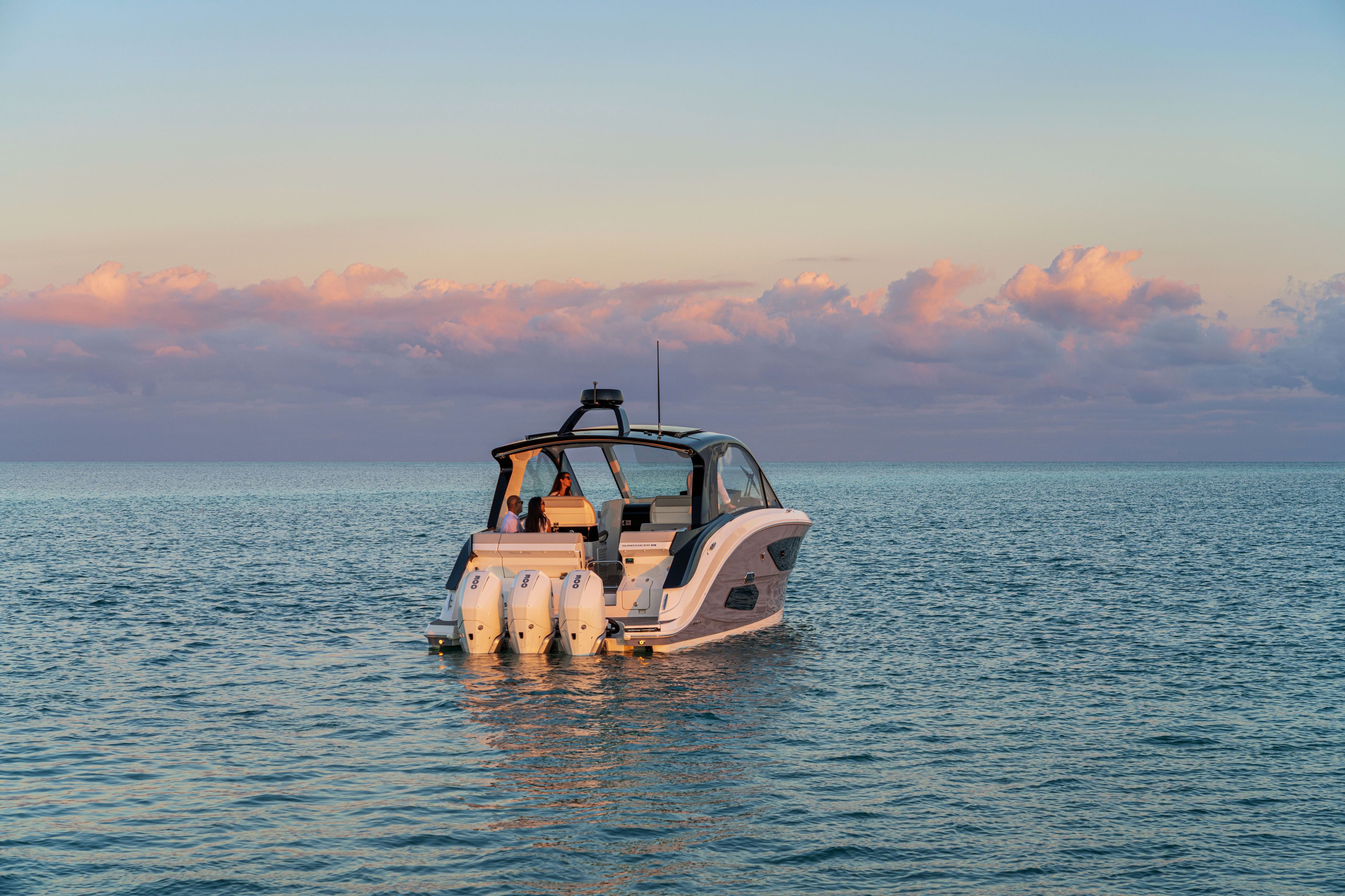 A 2026 Sea Ray Sundancer 370 Outboard on calm water at sunset.