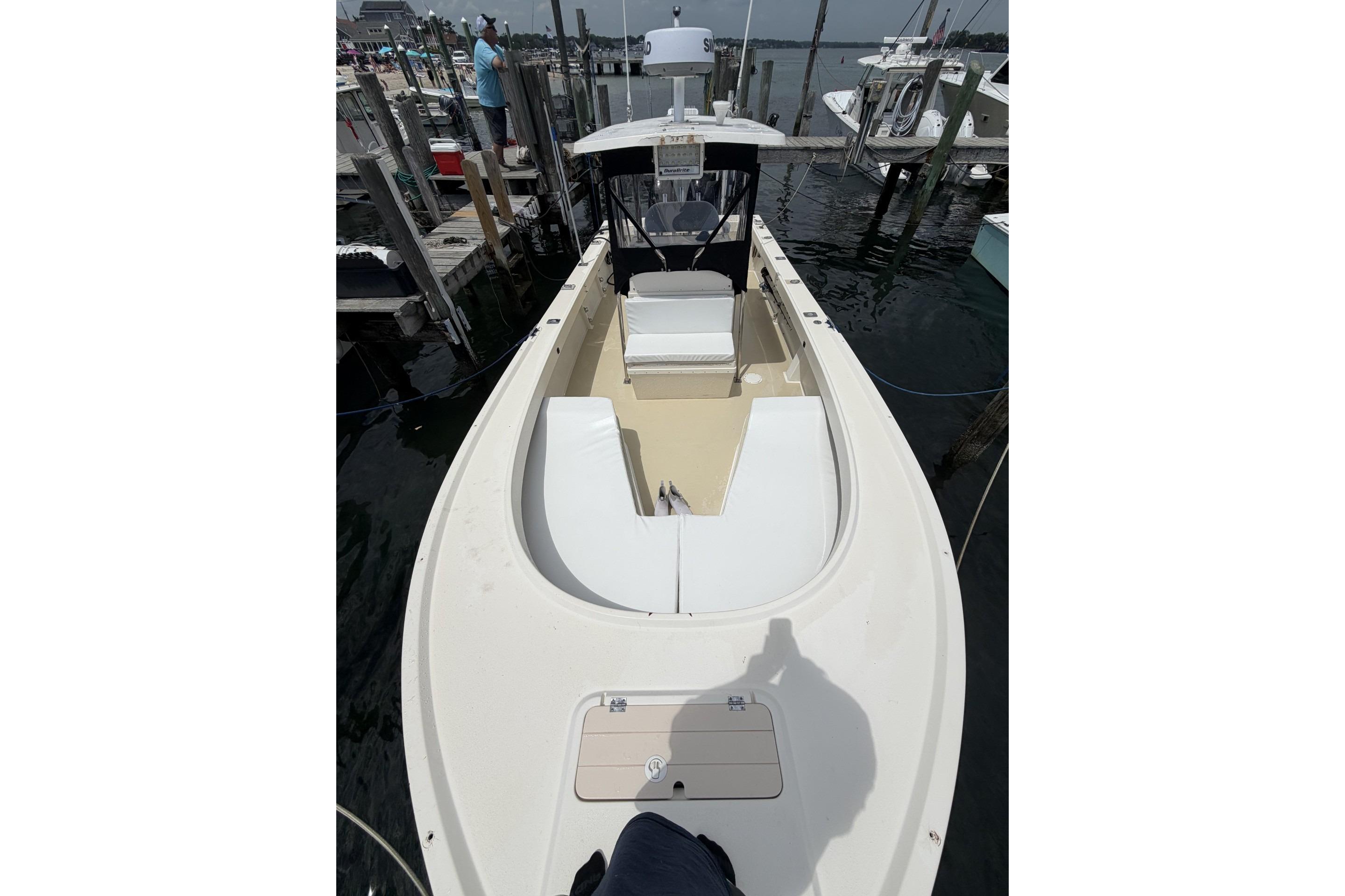 1999 Parker 2501 Center Console boat docked at marina, featuring spacious deck and seating.
