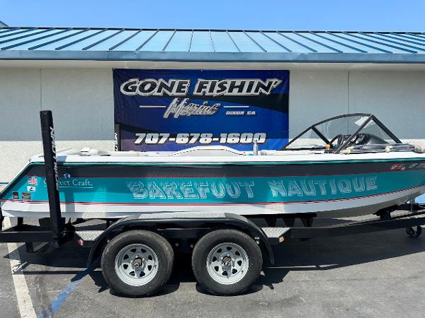 1992 Correct Craft Ski Nautique boat on trailer, parked outside "Gone Fishin'" store.