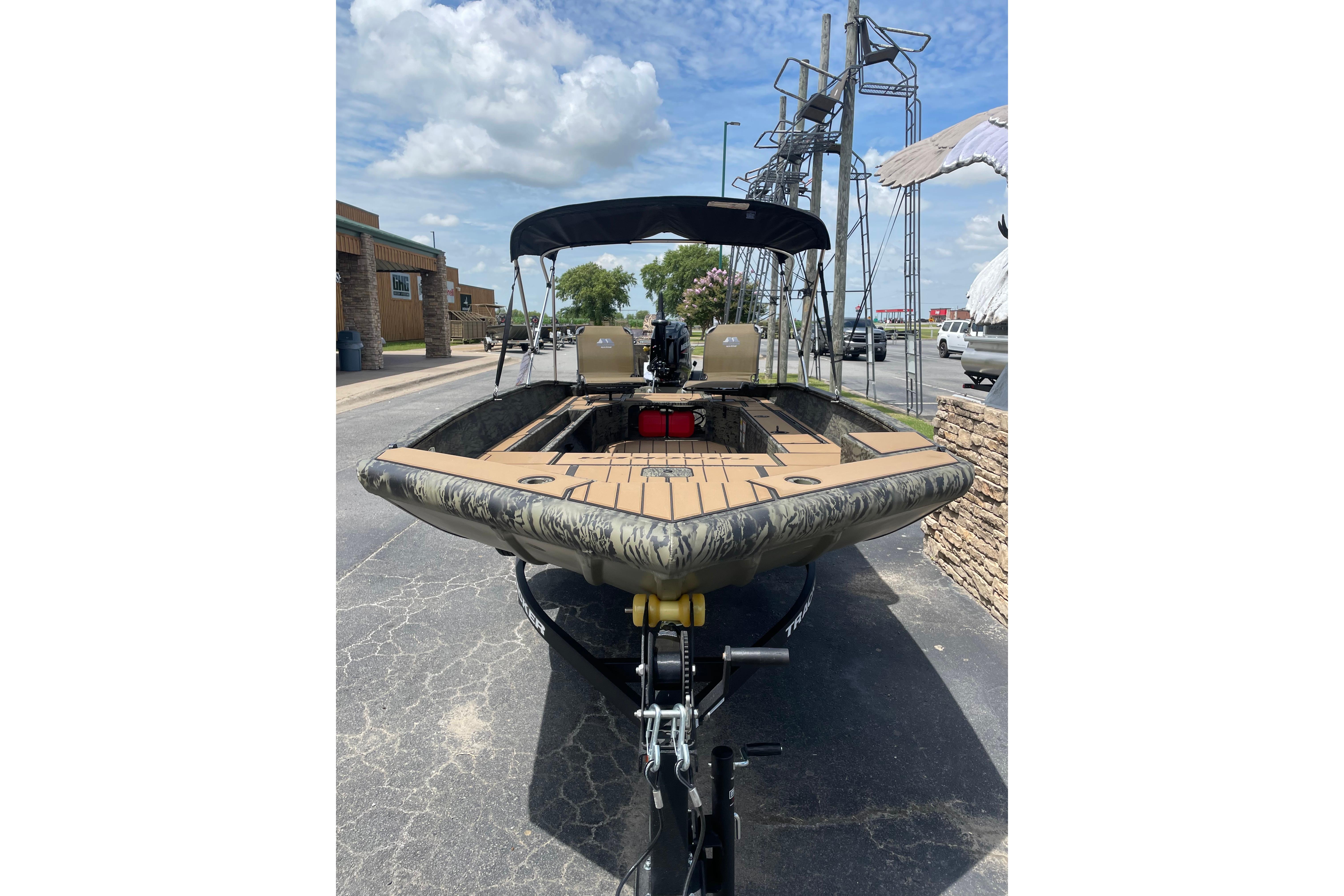 2026 Tracker Grizzly 1756 T Marsh boat with canopy, parked outdoors on a sunny day.