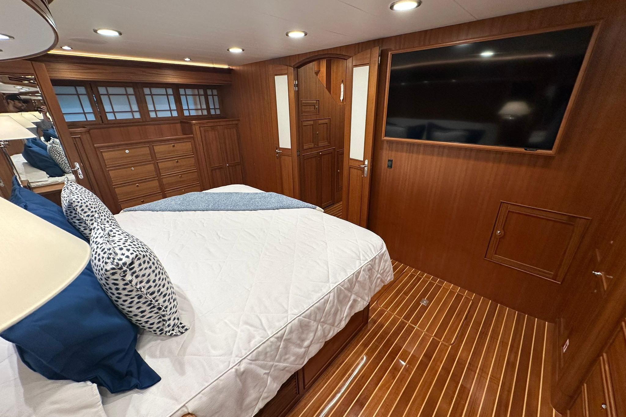 Luxurious cabin interior of 2023 Marlow Explorer 66E-CB yacht with wood finish and modern amenities.