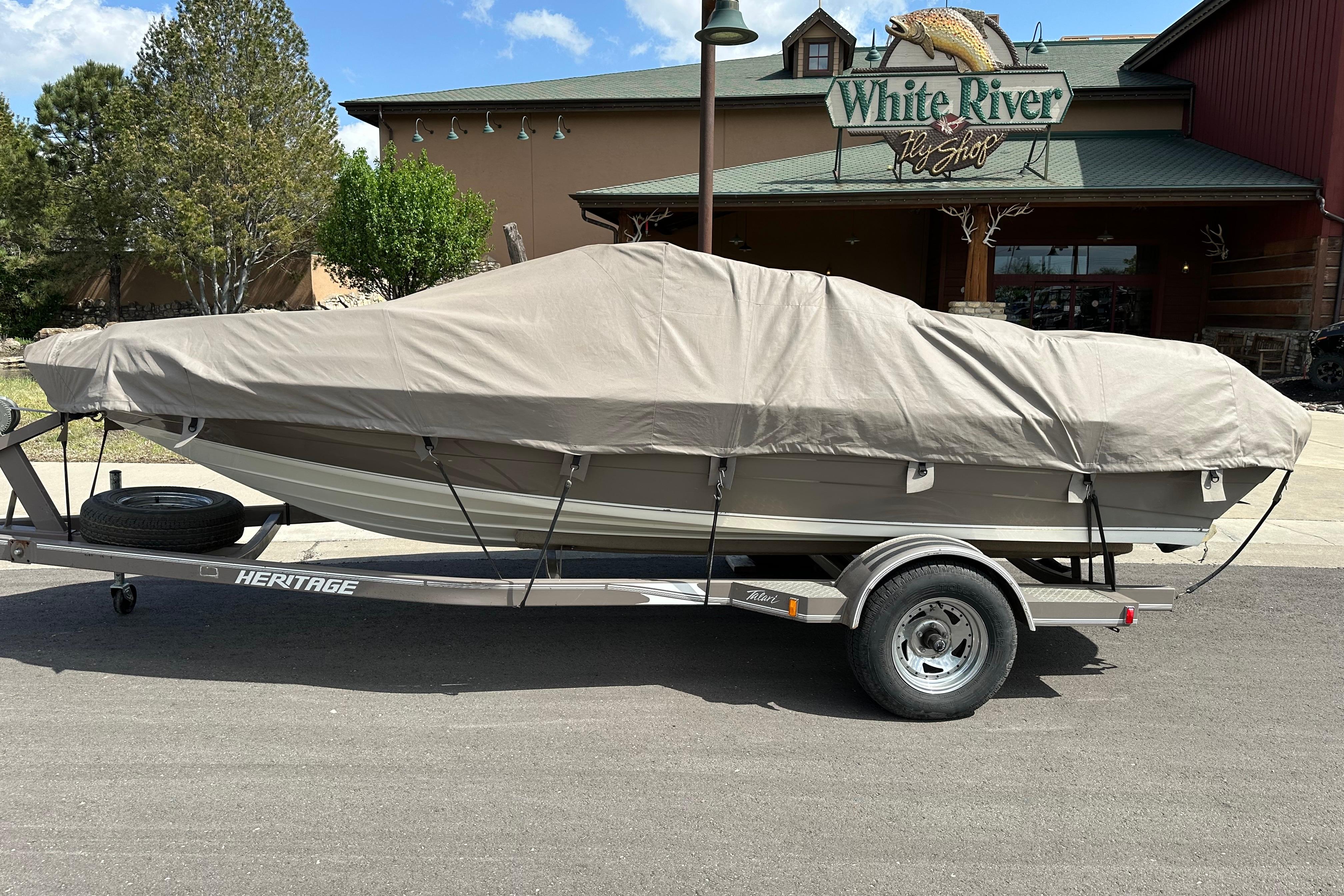 Covered 1995 Mariah 180 Shabah boat on trailer outside White River Fly Shop.