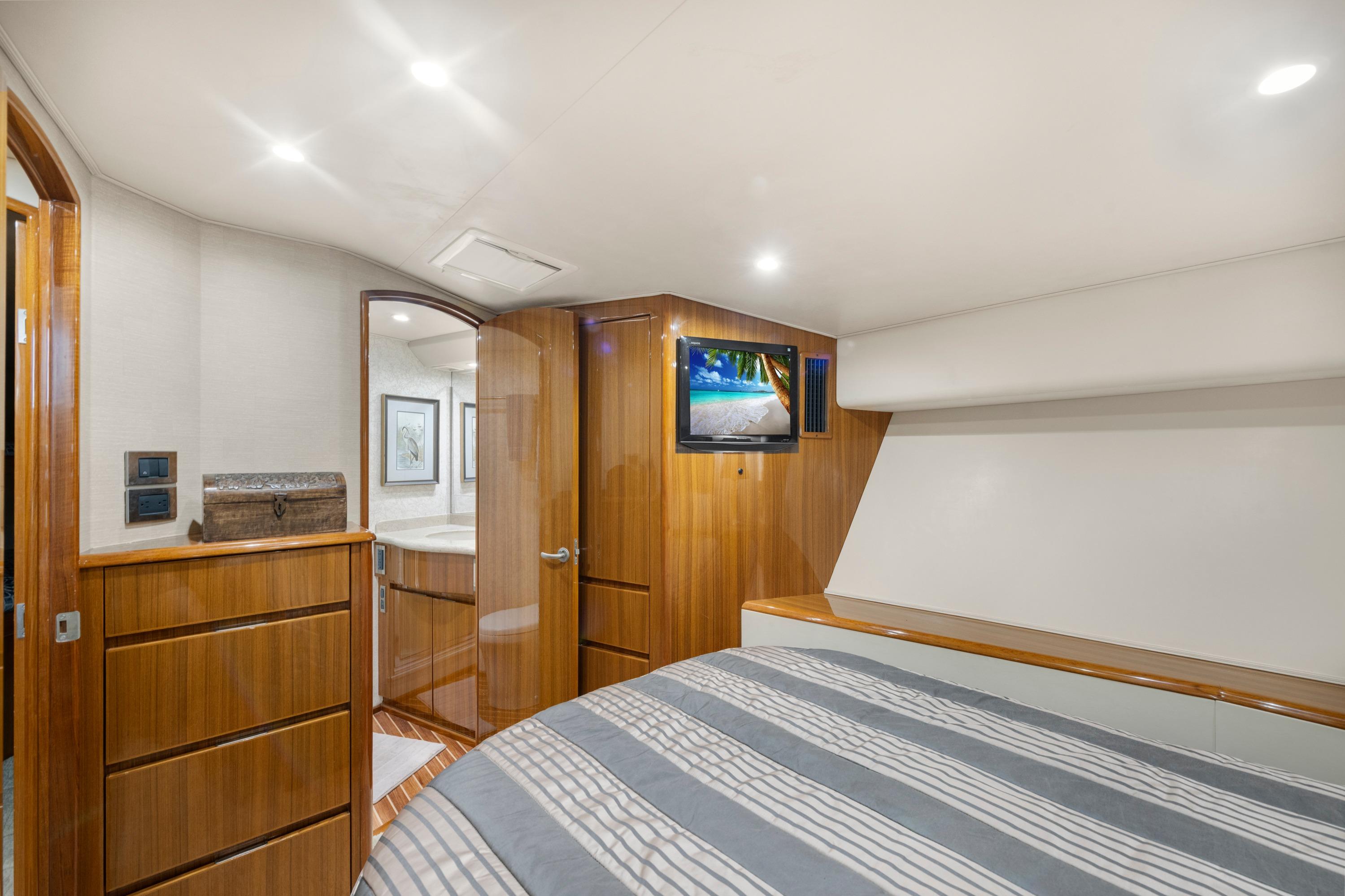 Luxurious 2009 Viking 50 Convertible yacht bedroom with wood accents and modern amenities.