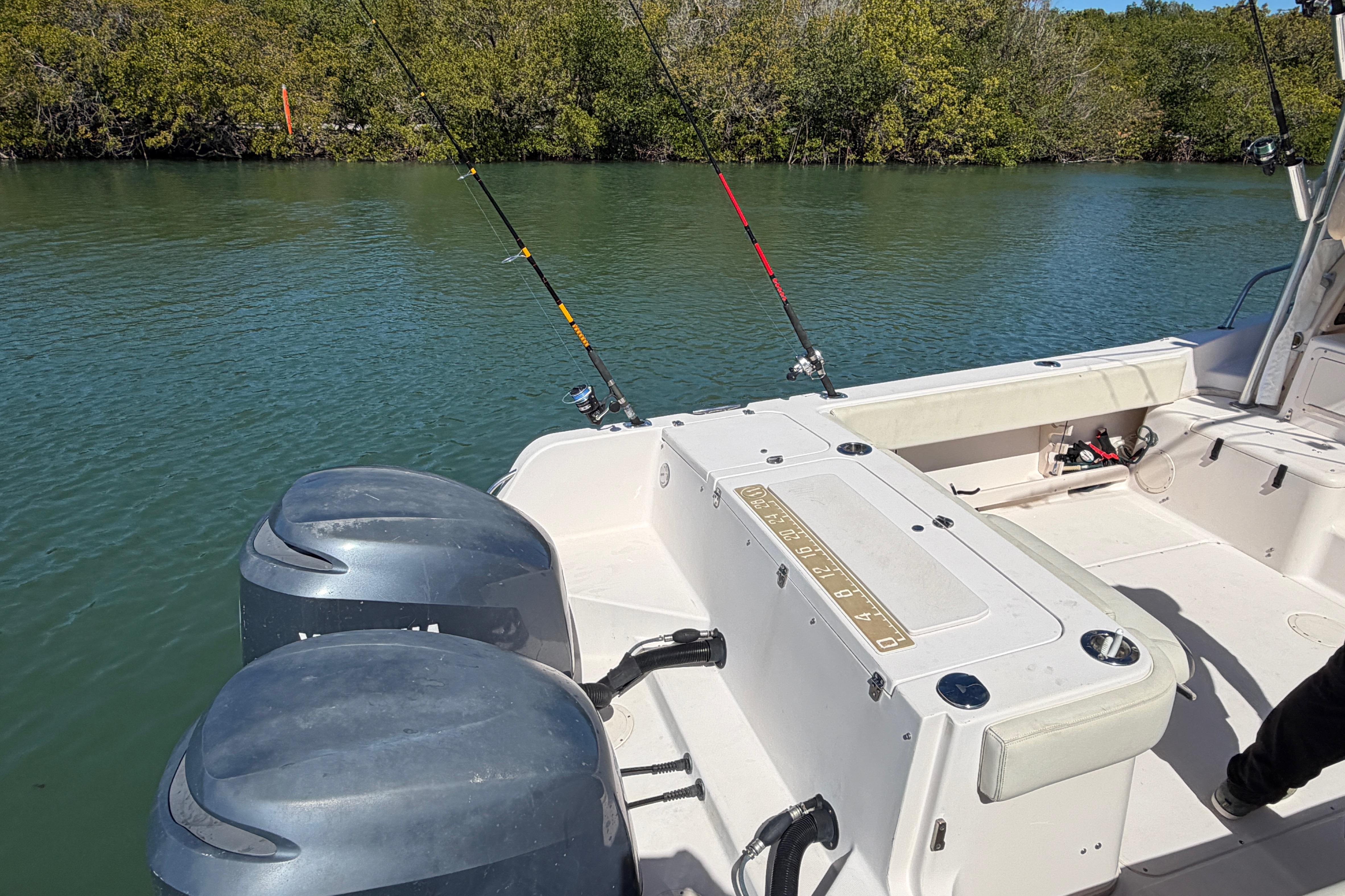 2006 Grady-White Sailfish 282 boat with fishing rods, dual engines, and scenic water backdrop.